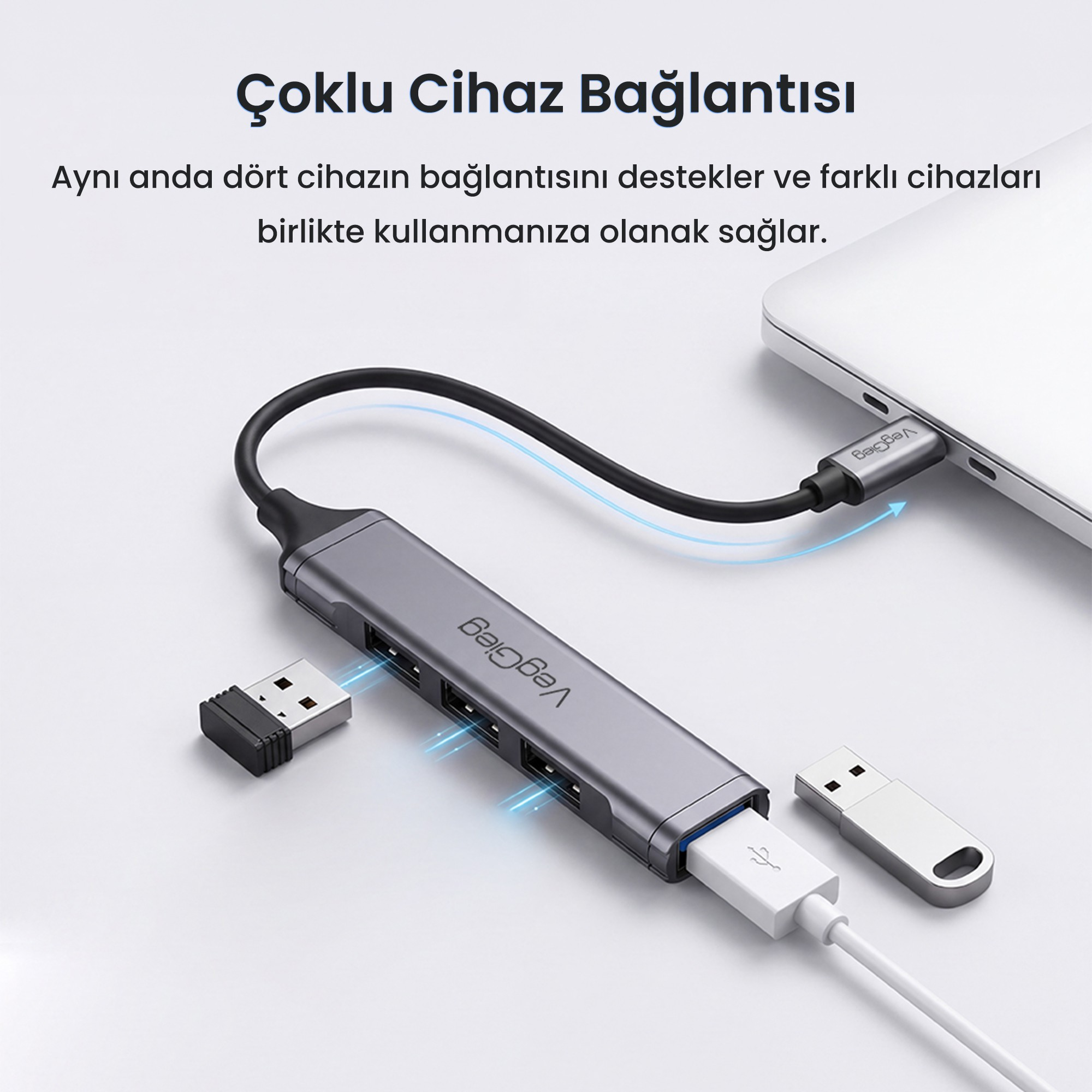 Gri bir USB çoklayıcı dizüstü bilgisayara bağlı ve birden fazla USB cihazını bağlıyor.