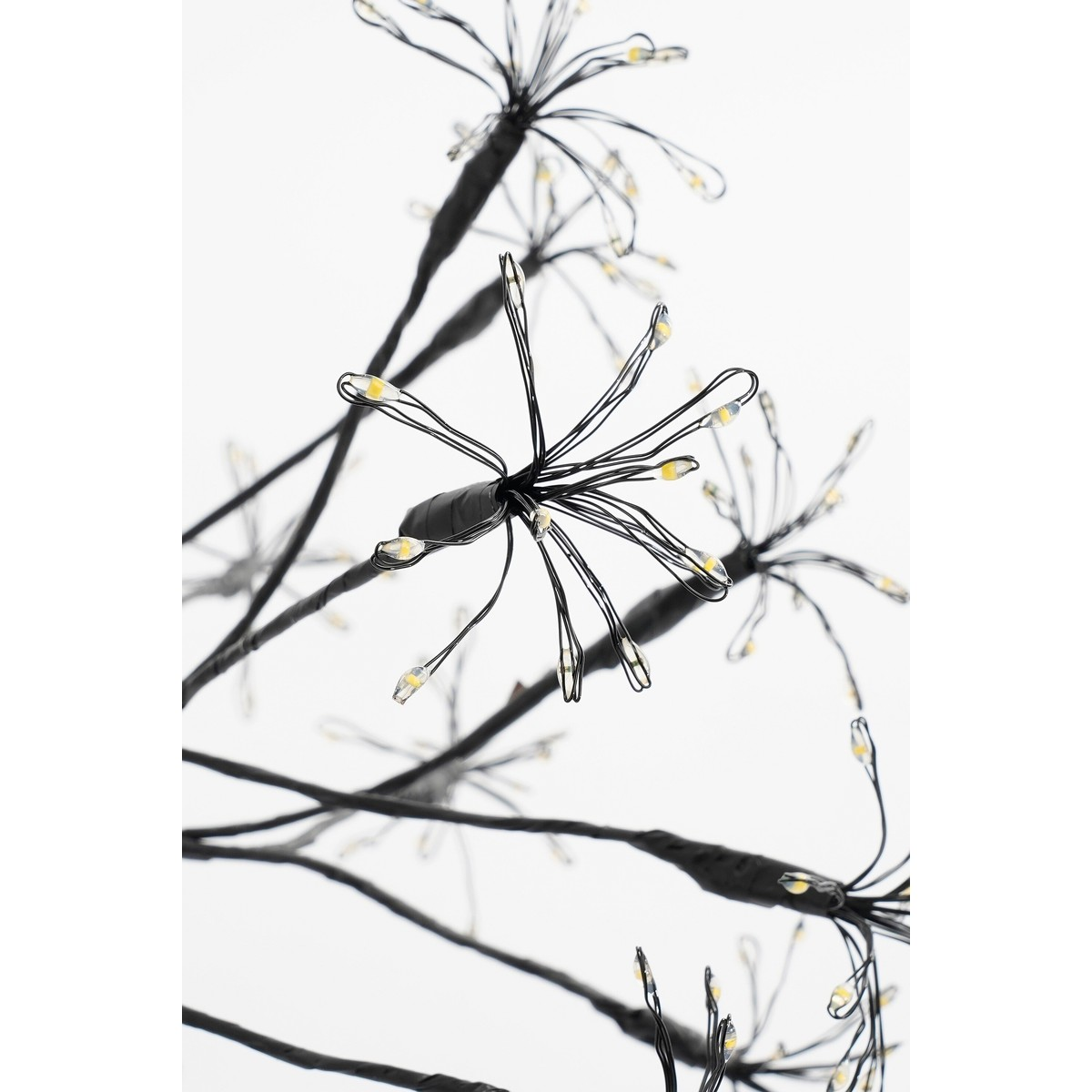 Black branches with small glowing LED lights at the ends on a bright background.