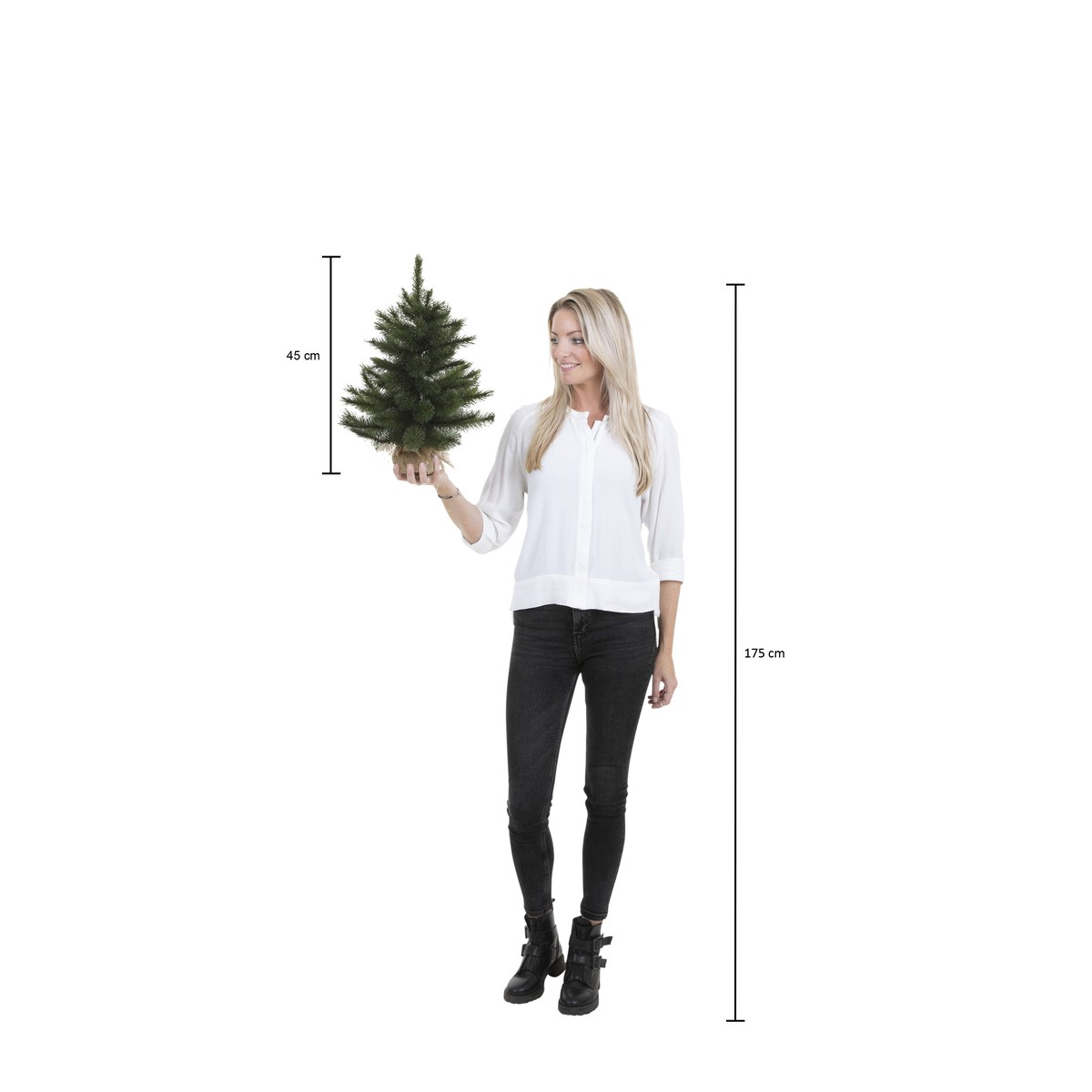 A blonde woman holds a small 45 cm Christmas tree against a white background.