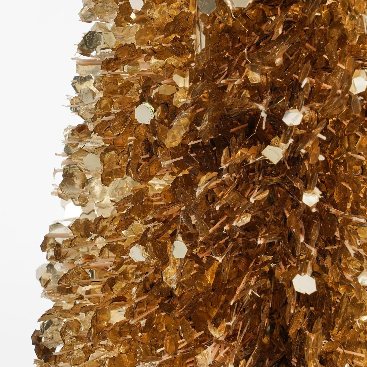 Shiny, golden artificial Christmas tree made of tinsel and sequins against a white background.