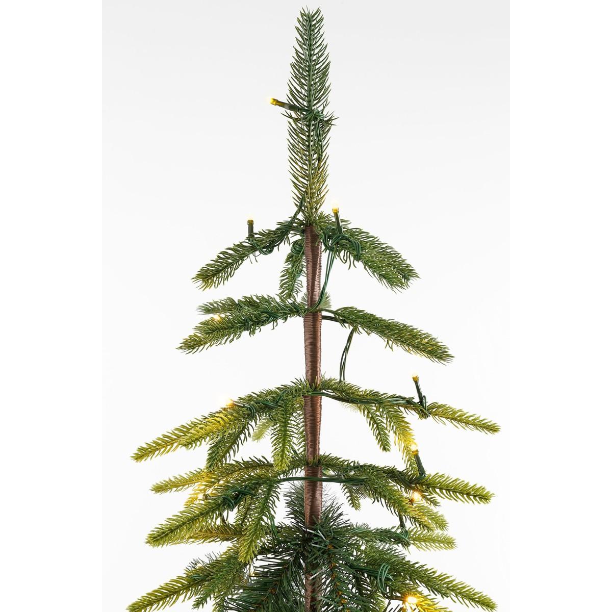 A slender artificial Christmas tree with thin green branches and integrated fairy lights.