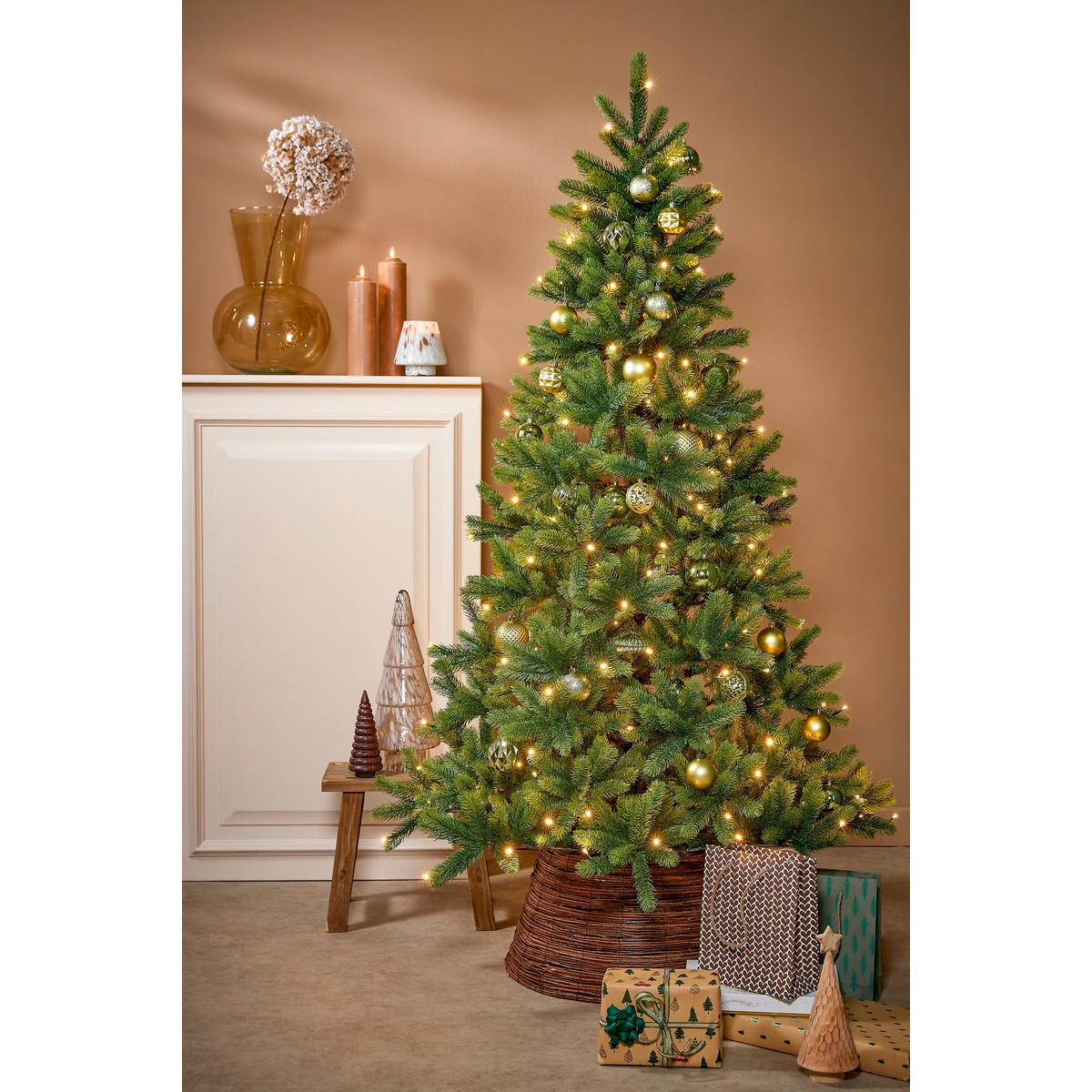 Decorated Christmas tree with lights, ornaments, and gifts in a room.