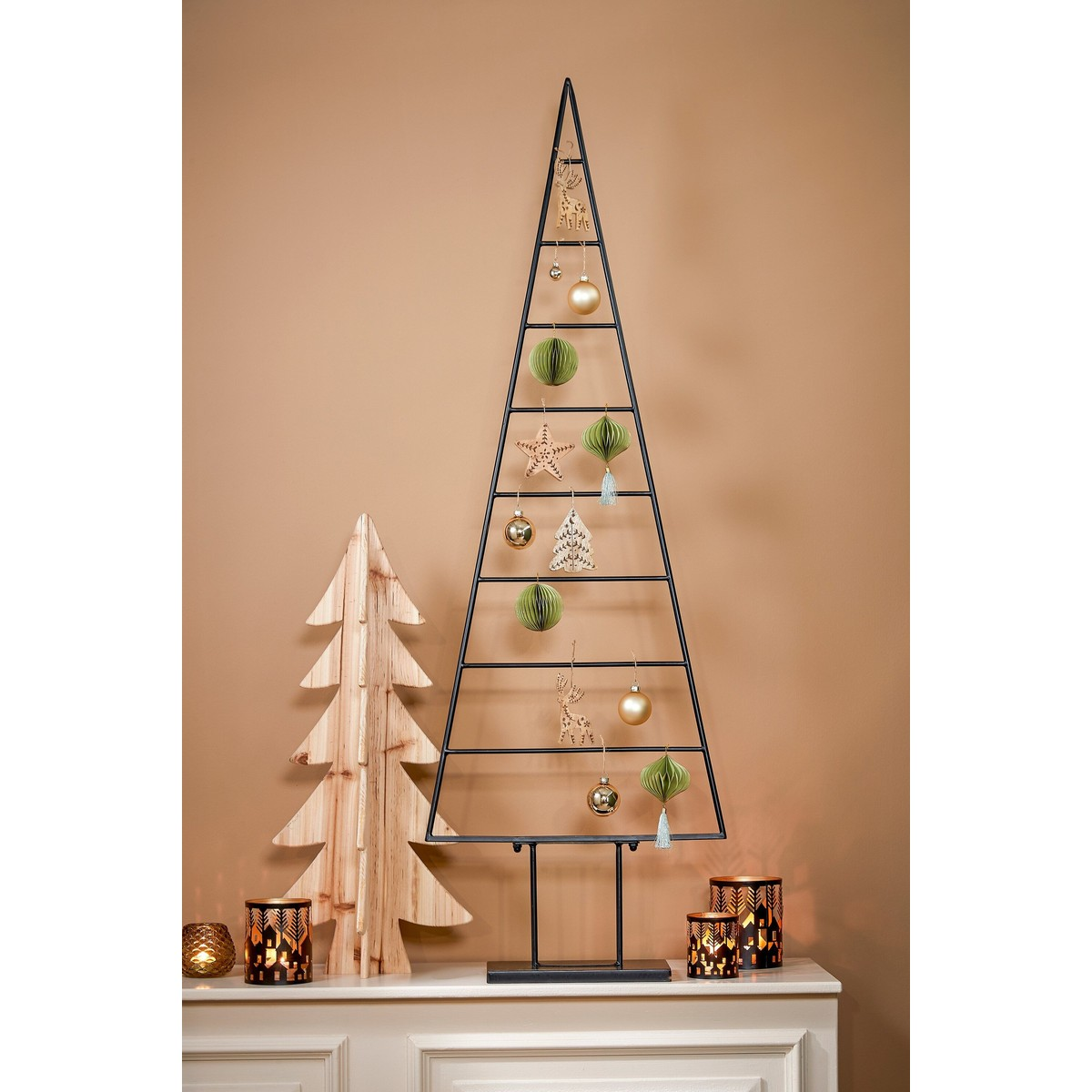 Modern metal Christmas tree decor on a sideboard with a wooden tree and candles.