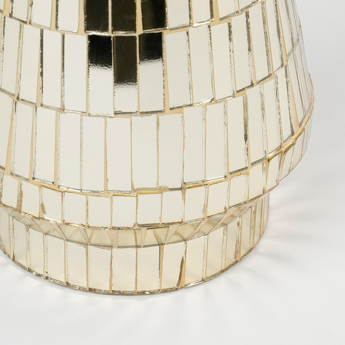 A gold mirrored mosaic vase on a white background.