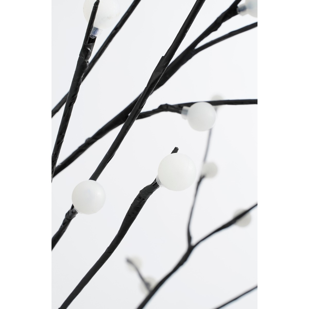 Black branches with round white glass globes against a light background.