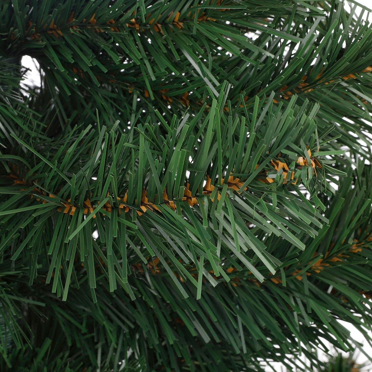 Close-up of artificial green pine tree branches with brown stems.