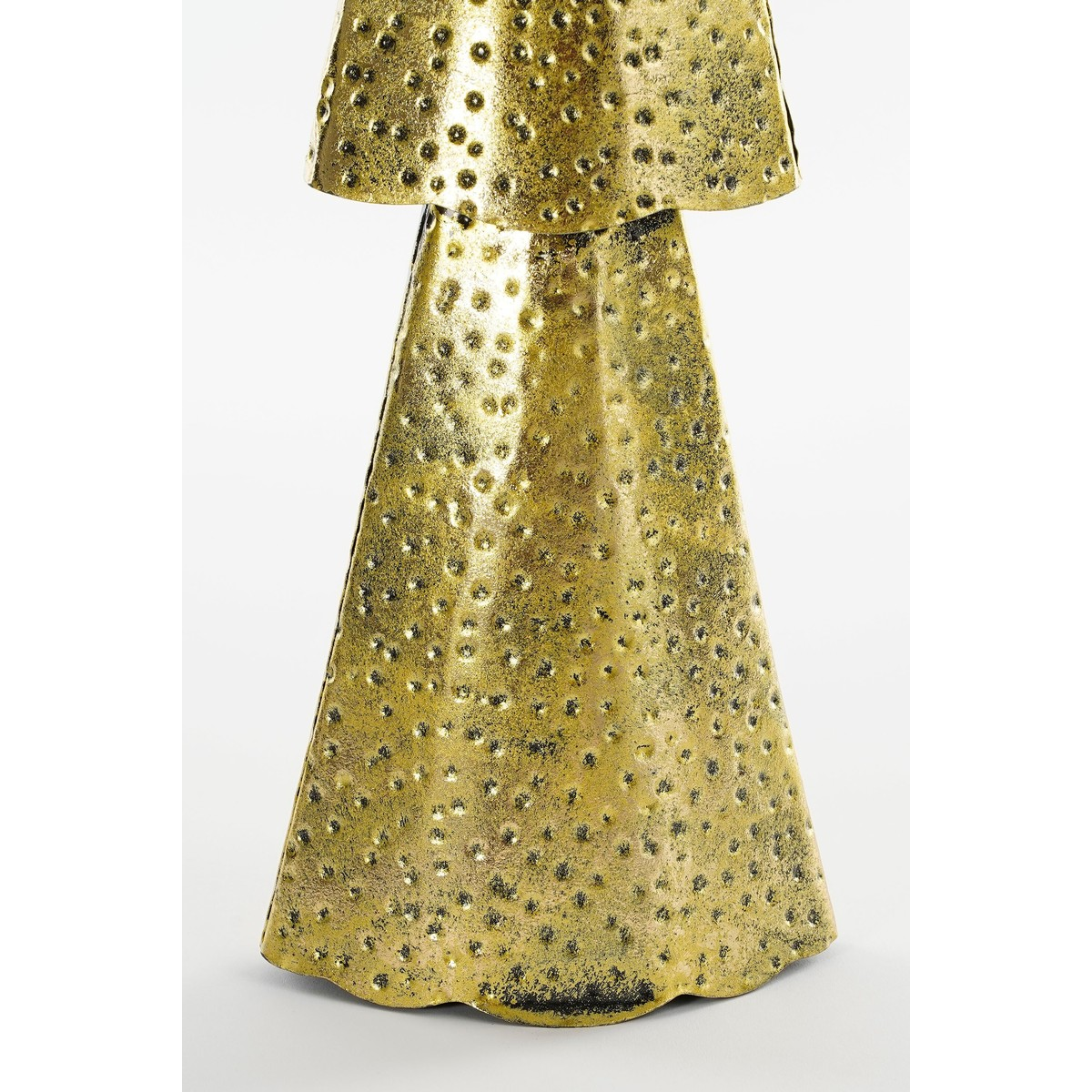 A gold-colored sculpture with a textured surface and dotted pattern against a white background.