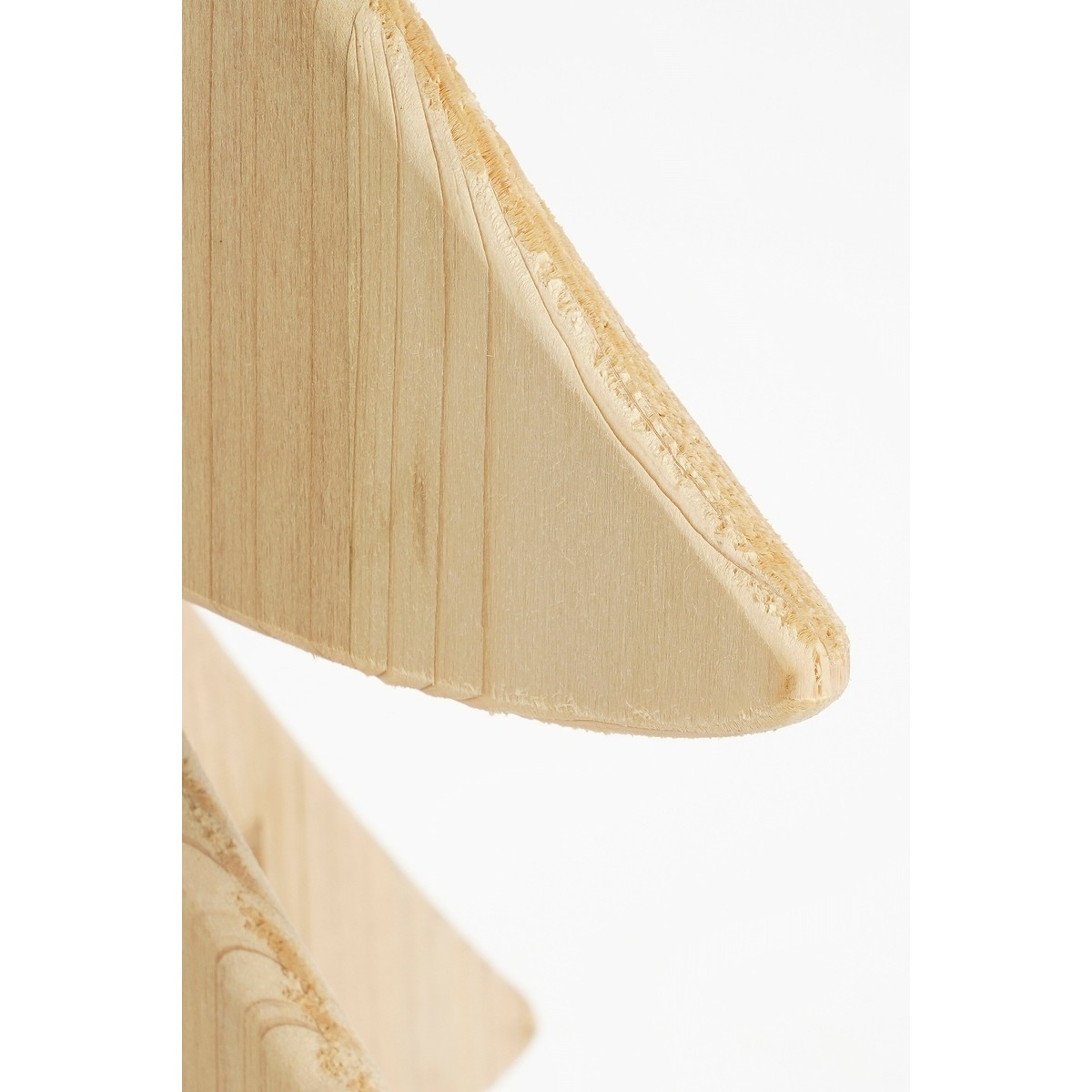 Close-up of a wooden structure with visible grain and light surface against a white background.