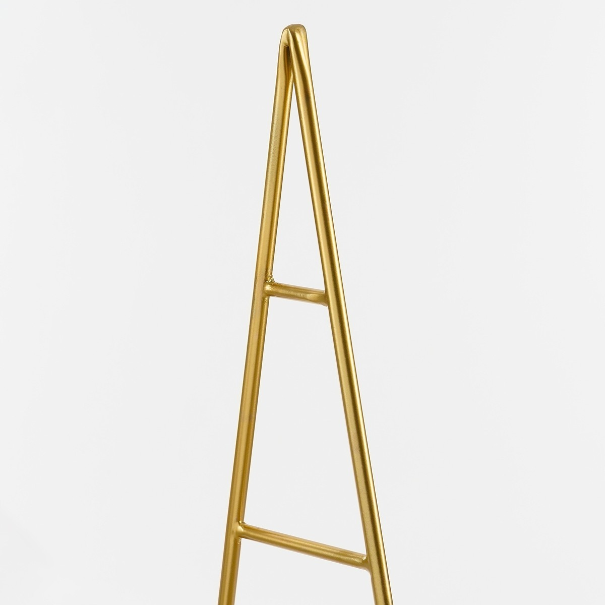 A shiny golden metal stand in a triangular shape against a white background.