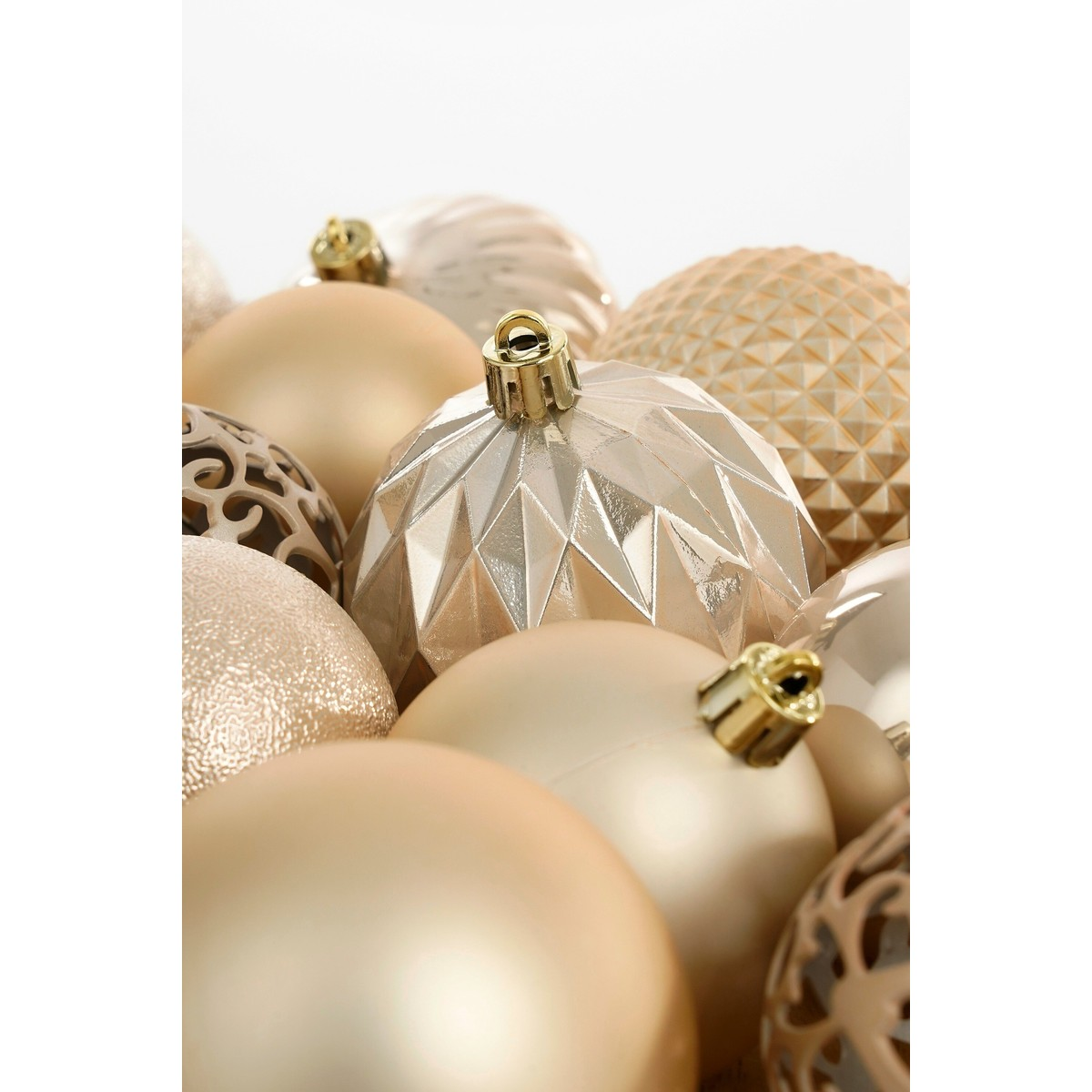 A close-up of glossy, gold Christmas baubles with various patterns against a white background.