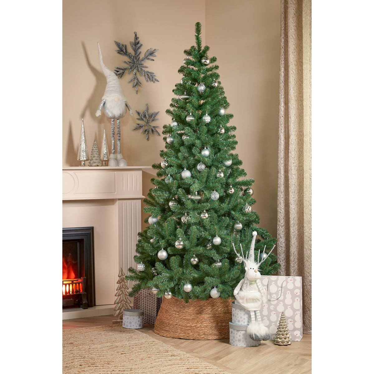 A decorated Christmas tree stands in a room in front of a fireplace with holiday decor.