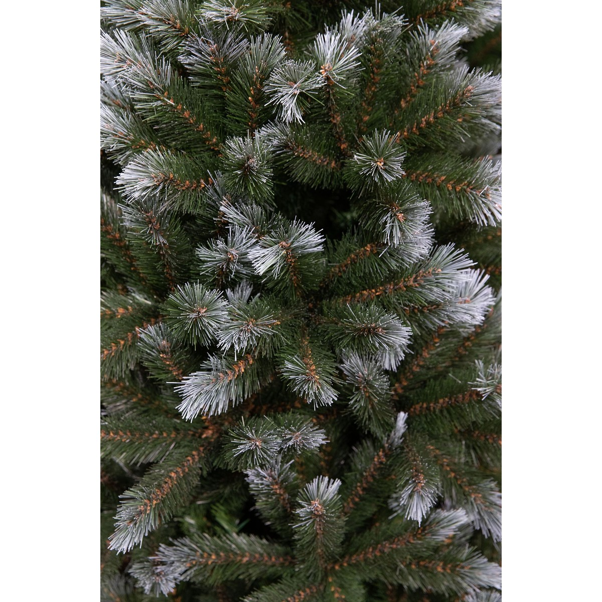 Close-up of a dense artificial Christmas tree with frosted green needles.