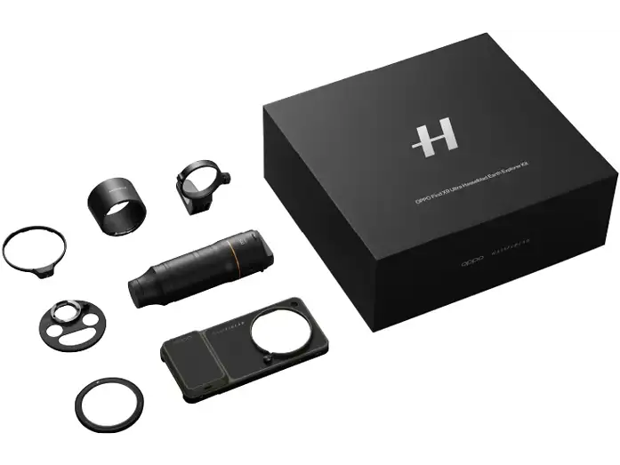 Ein schwarzer Hasselblad Explorer-Kit Karton und diverse Kamerazubehörteile liegen auf einer weißen Oberfläche.