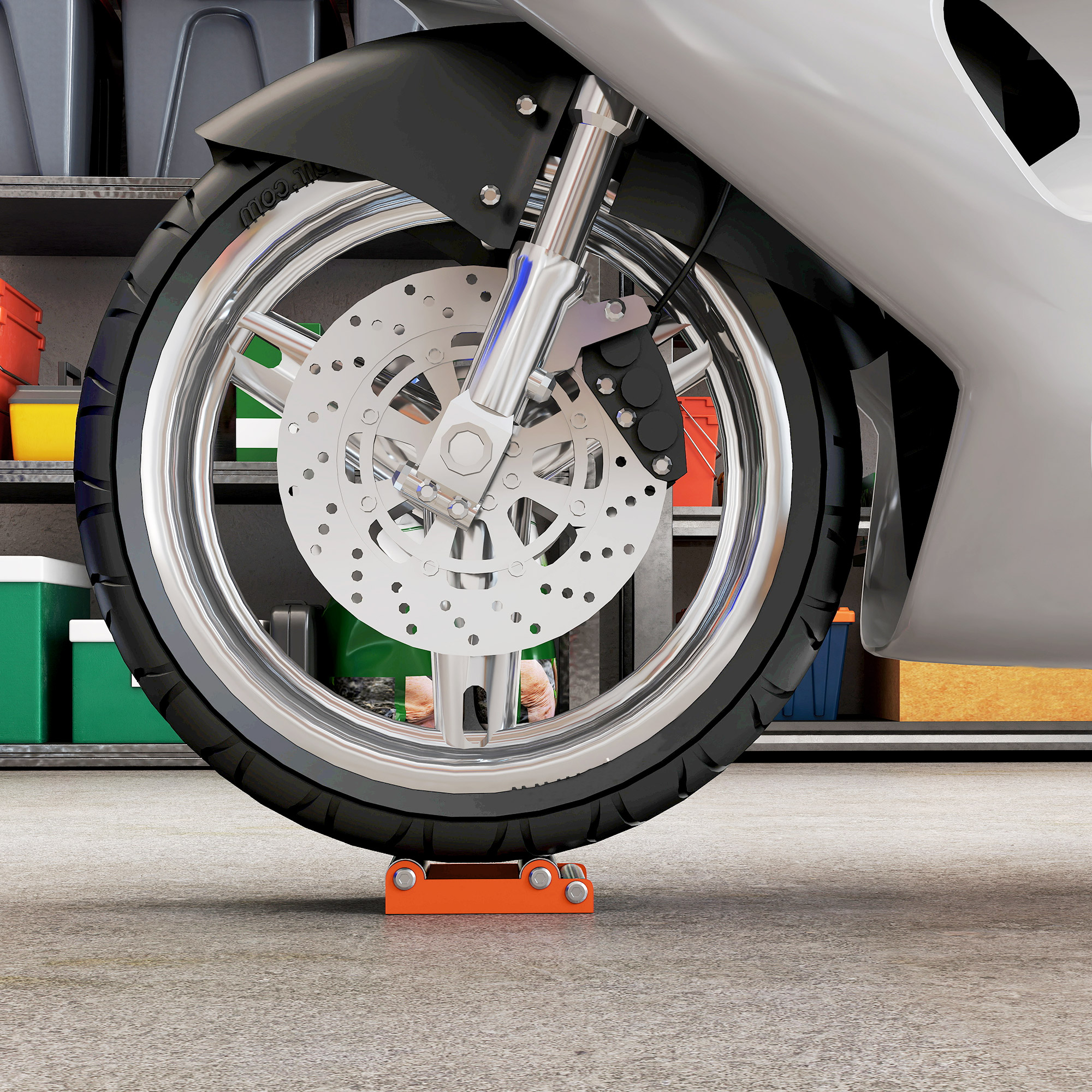 Primer plano de la rueda delantera de una moto con llanta cromada y freno de disco, sobre un calzo naranja en un garaje.