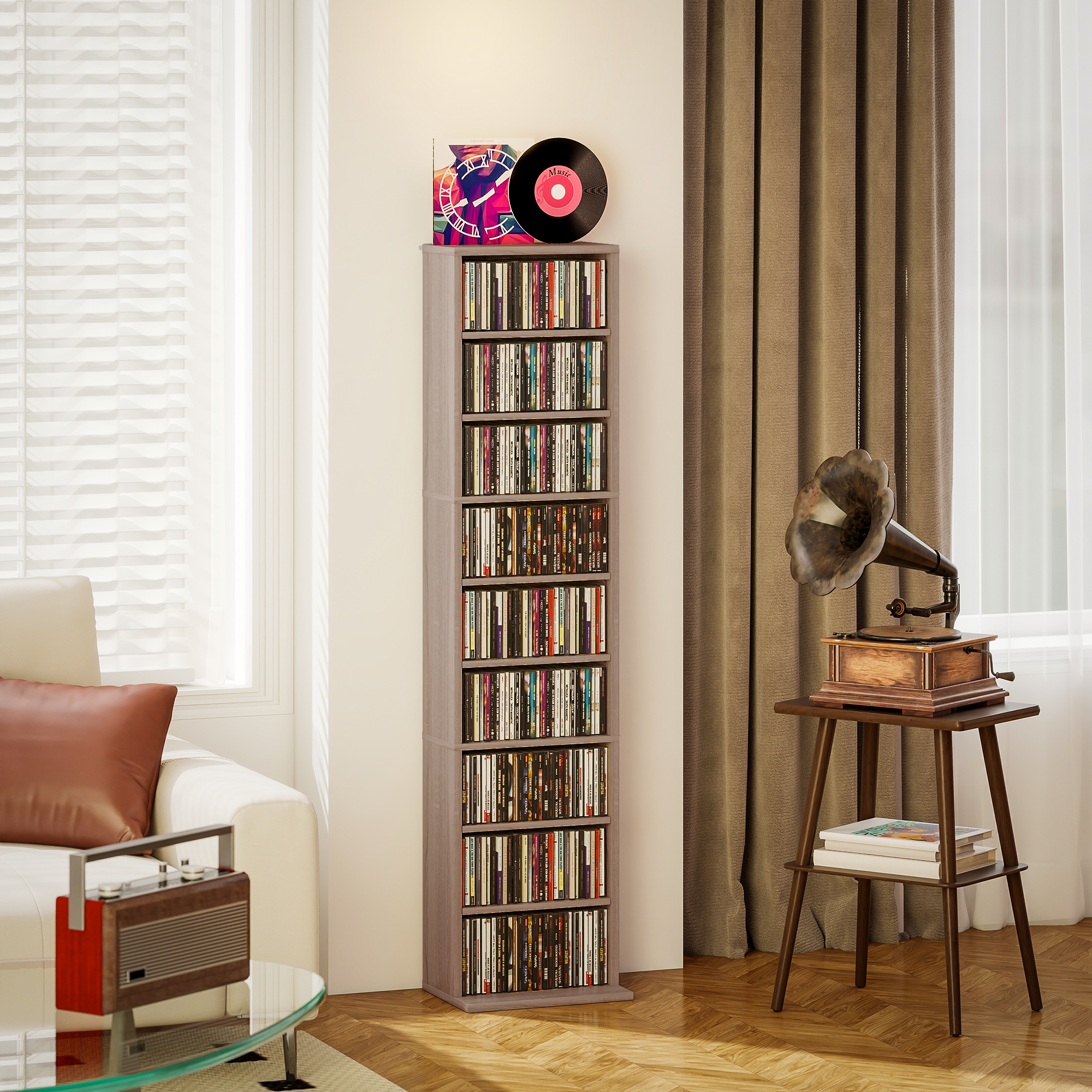 Una torre de CD alta y delgada llena de discos está junto a un gramófono en una mesa en una habitación.