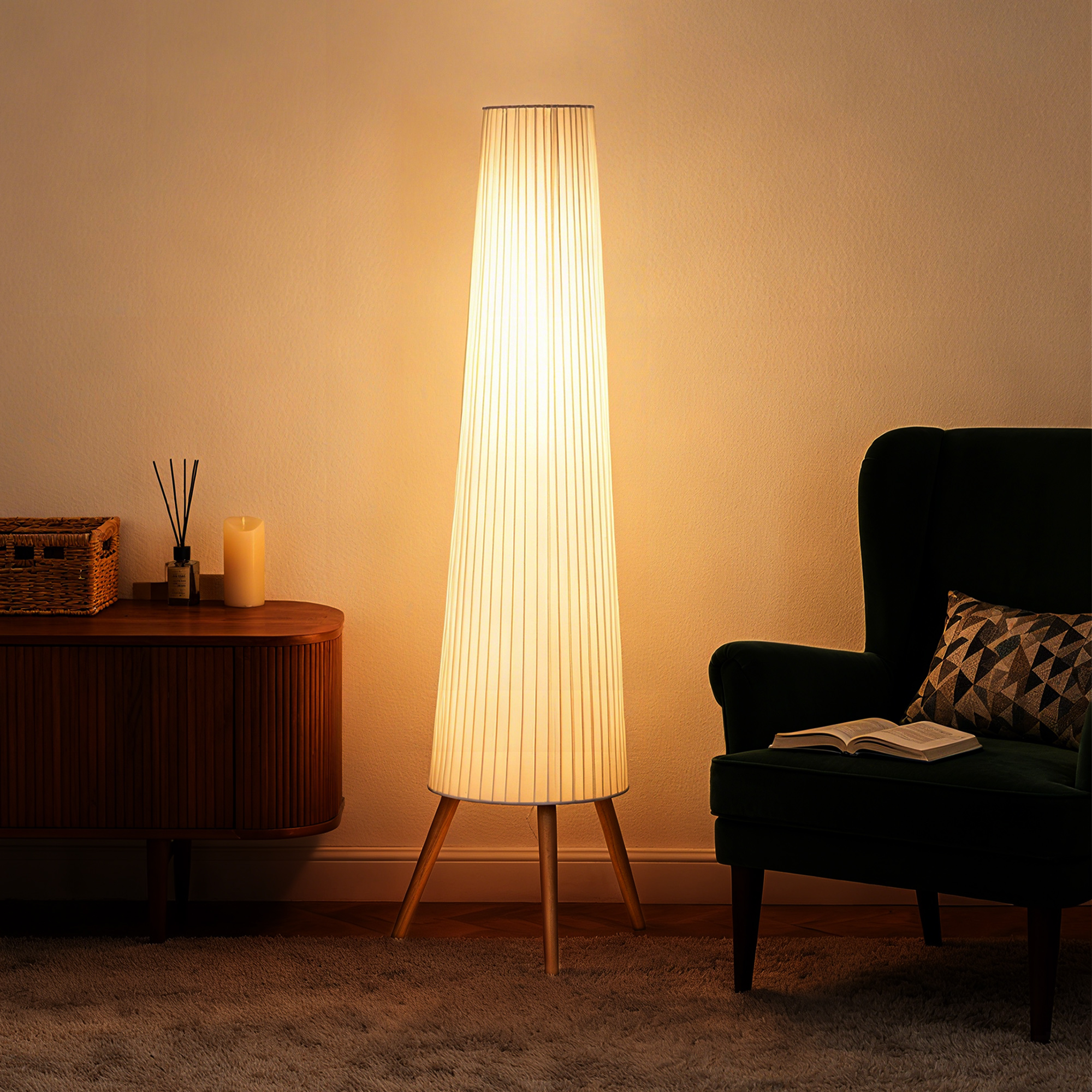 Una lámpara de pie brillante se encuentra en una habitación acogedora con un mueble de madera y un sillón verde.