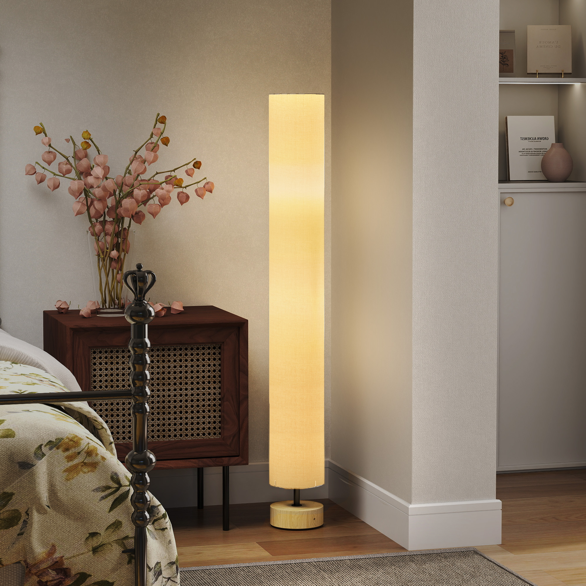 Una lámpara de pie cilíndrica y brillante se encuentra en la esquina de una habitación junto a un mueble con flores.