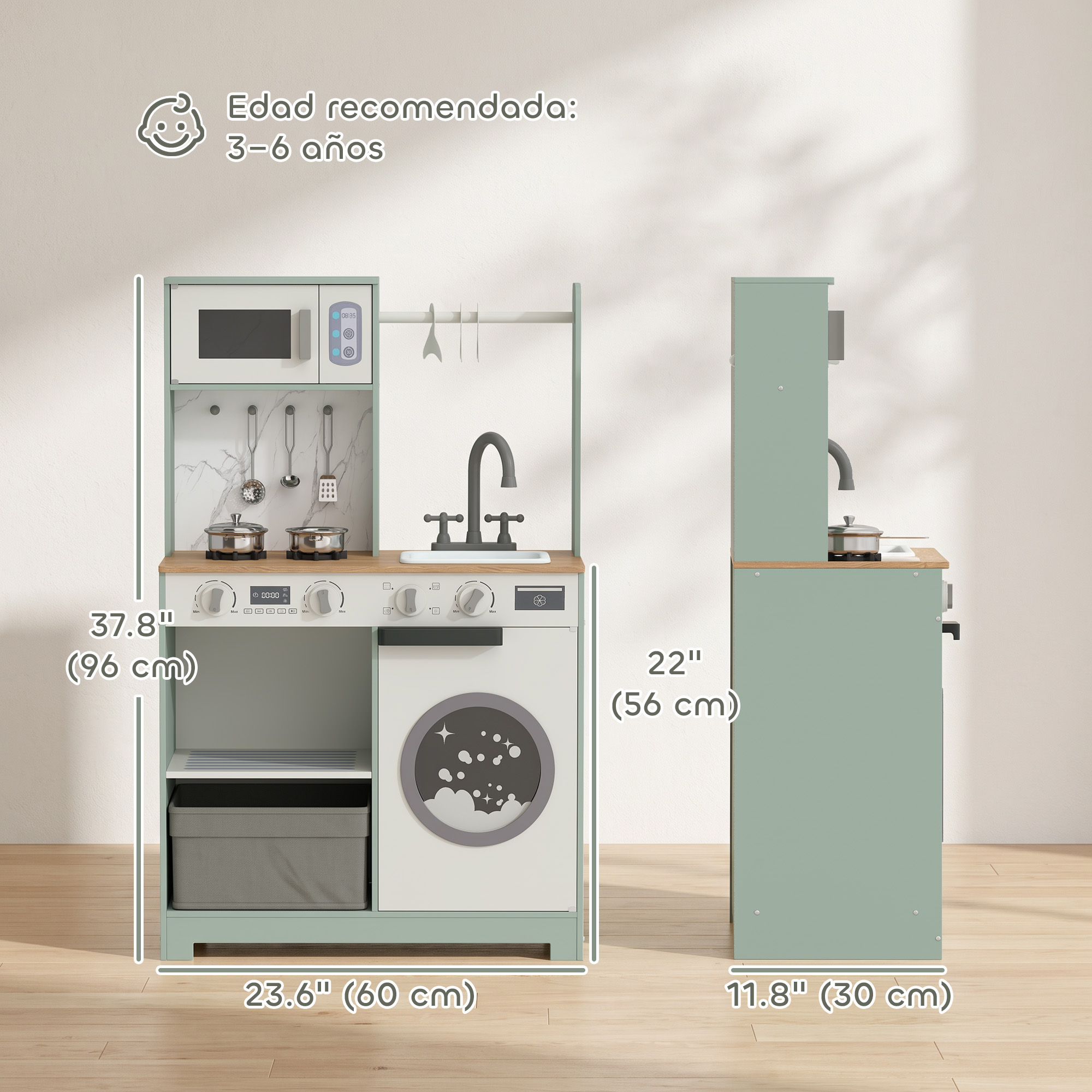 Cocina de juguete verde y blanca con medidas y accesorios ante una pared blanca.