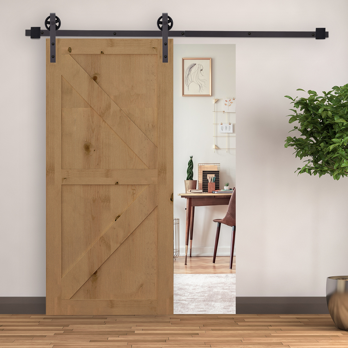 Una puerta corredera de madera en un riel negro revela una habitación con un escritorio y una planta.