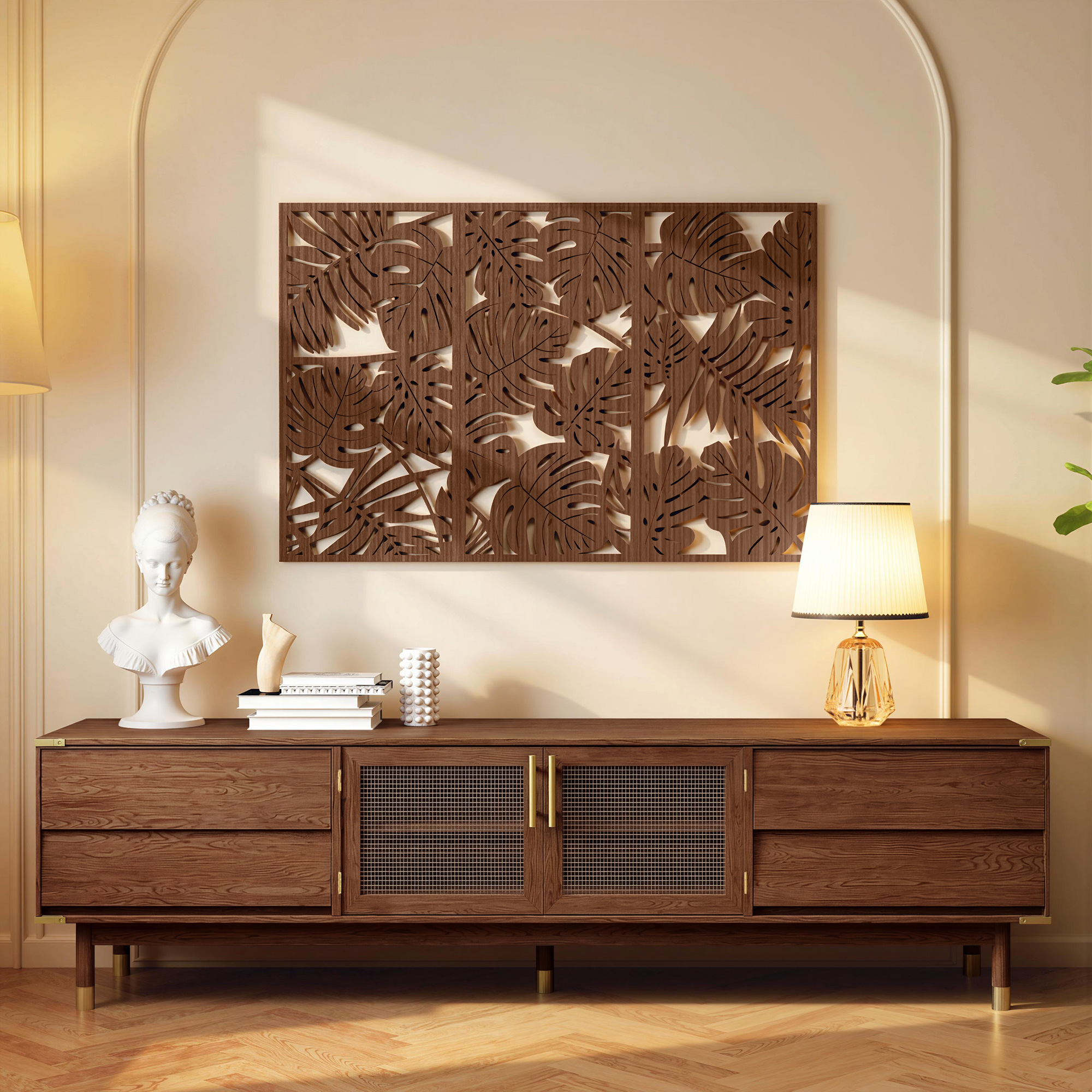 Un arte de pared de hojas de palma de madera cuelga sobre un gabinete de madera oscura con decoracion y una lampara.