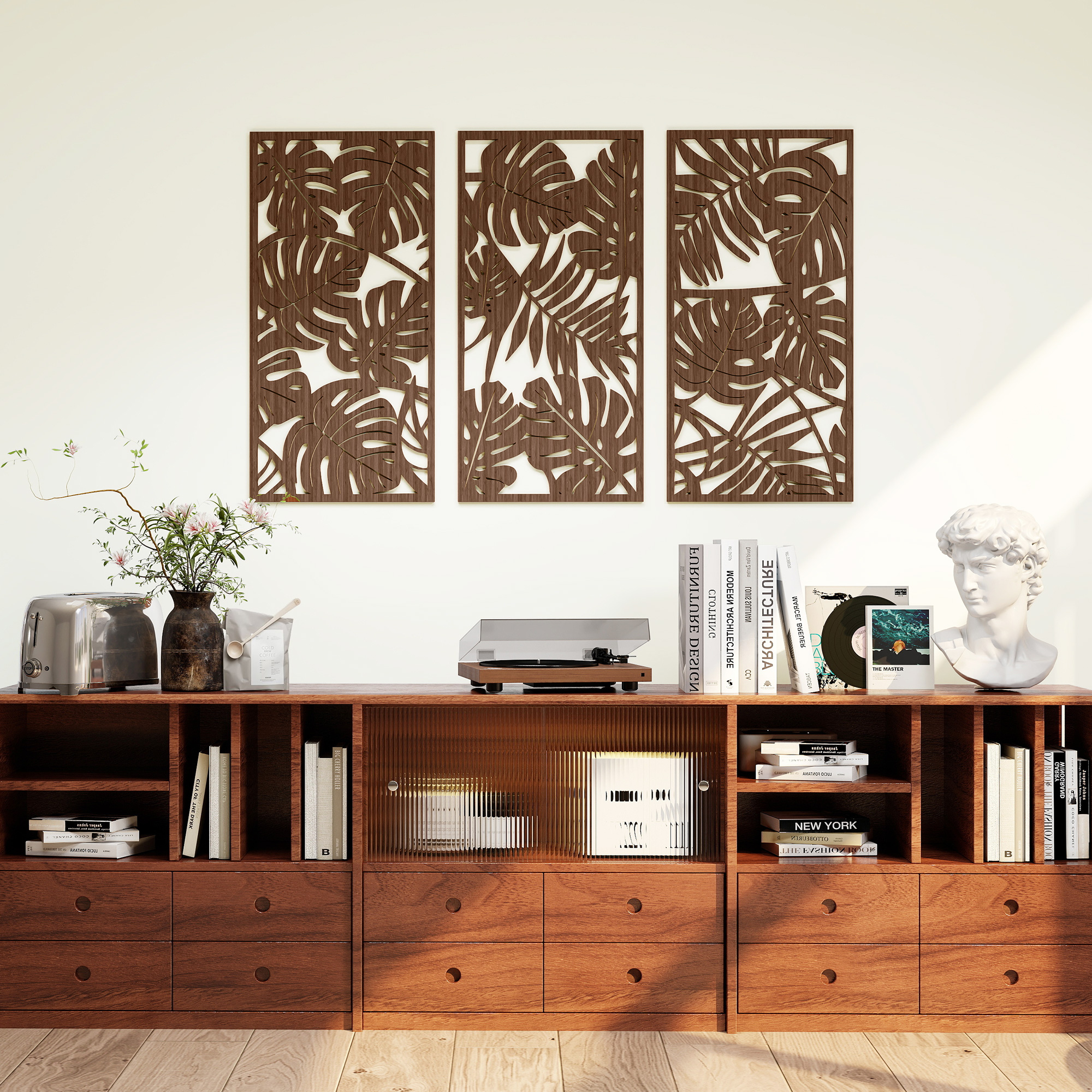 Un aparador de madera sostiene plantas, un tocadiscos, libros y un busto, con tres paneles decorativos en la pared.