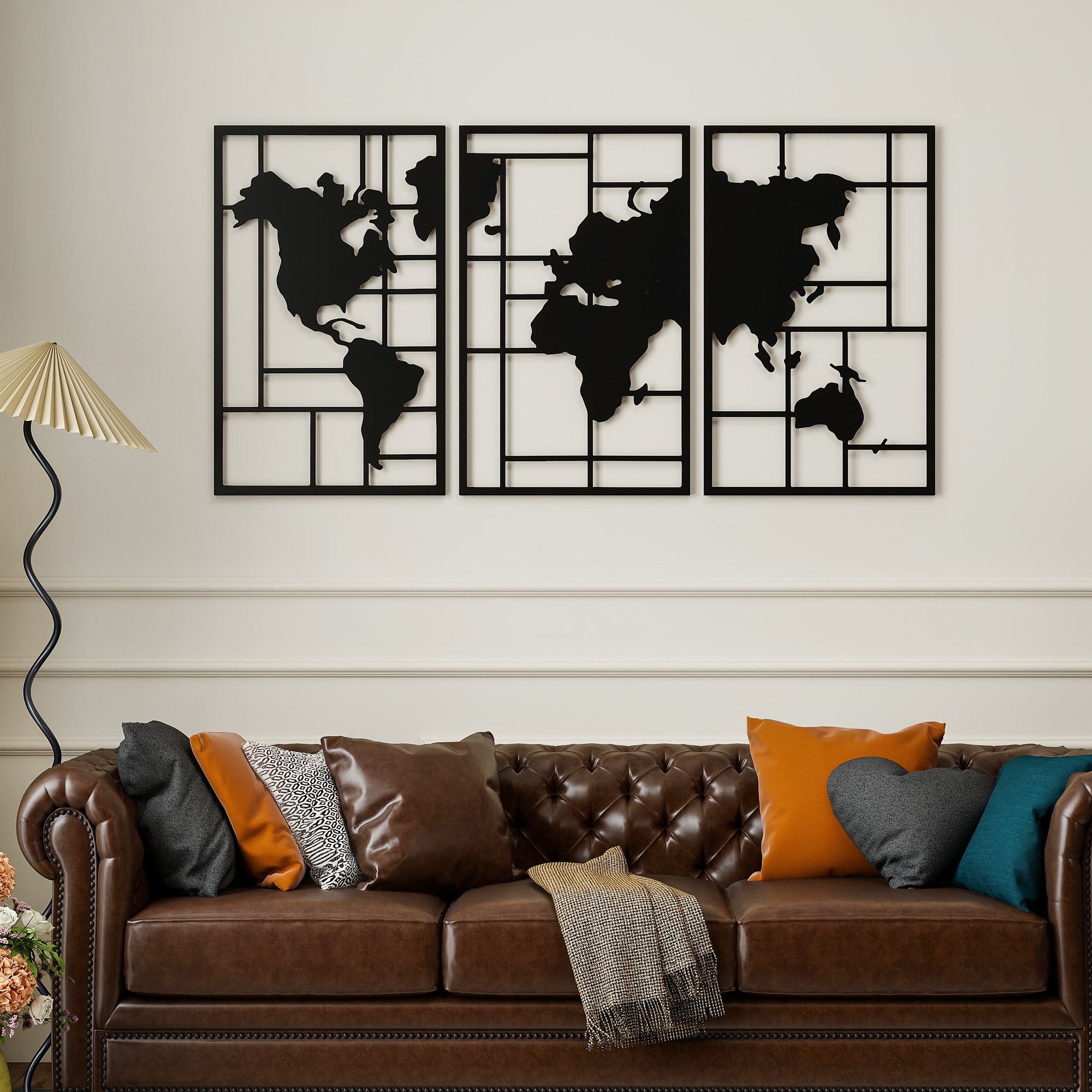 Un sofá de cuero marrón con cojines de colores se encuentra bajo un mapa mundial de metal negro.