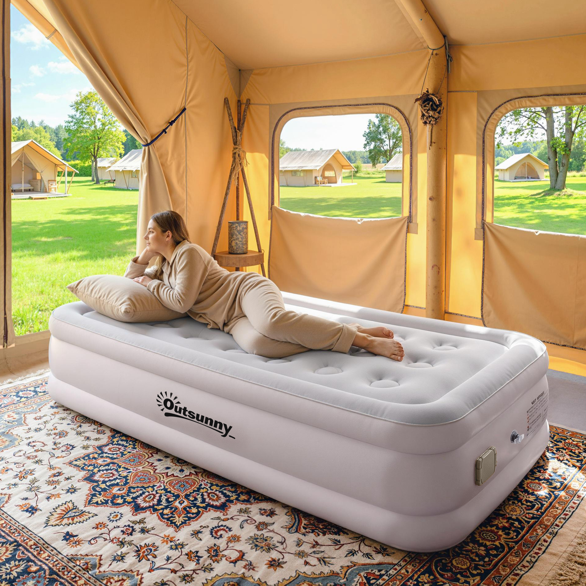 Una mujer yace en una cama de aire blanca Outsunny dentro de una lujosa tienda de glamping con vistas verdes.