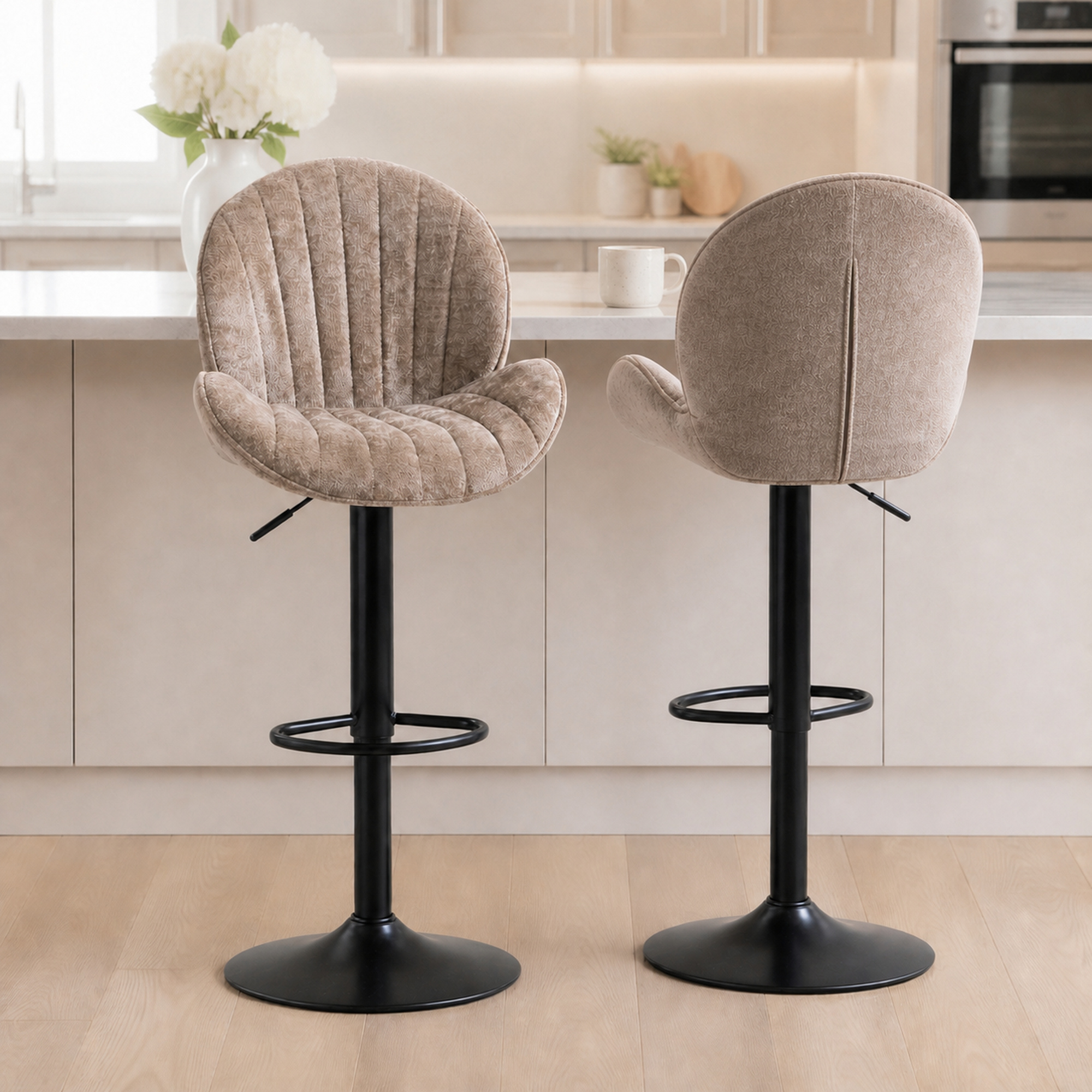 Dos taburetes de bar tapizados con asientos beige y bases de metal negro en una cocina moderna.