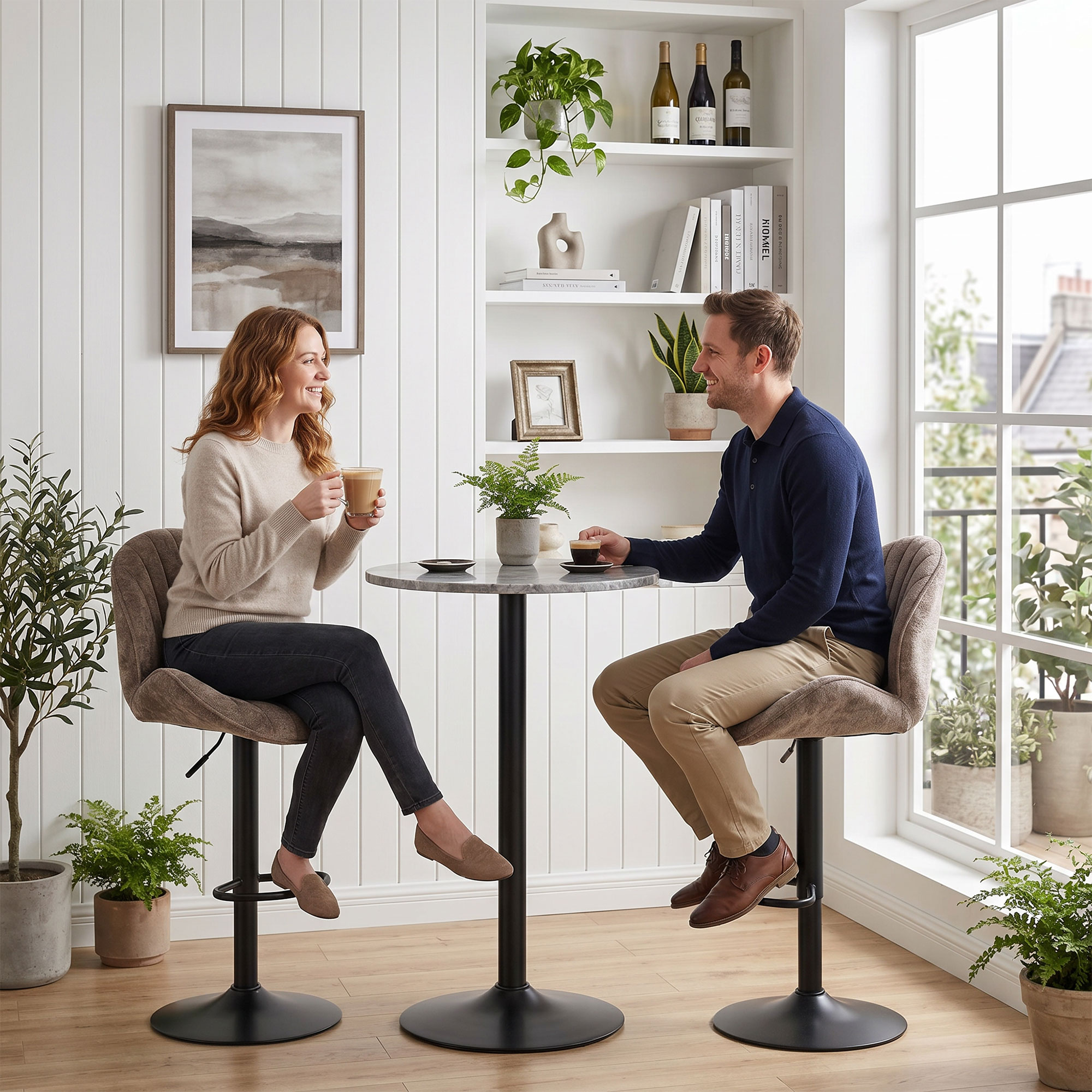 Una pareja se sienta en taburetes en una mesa pequeña, bebiendo café en una habitación luminosa decorada con plantas.