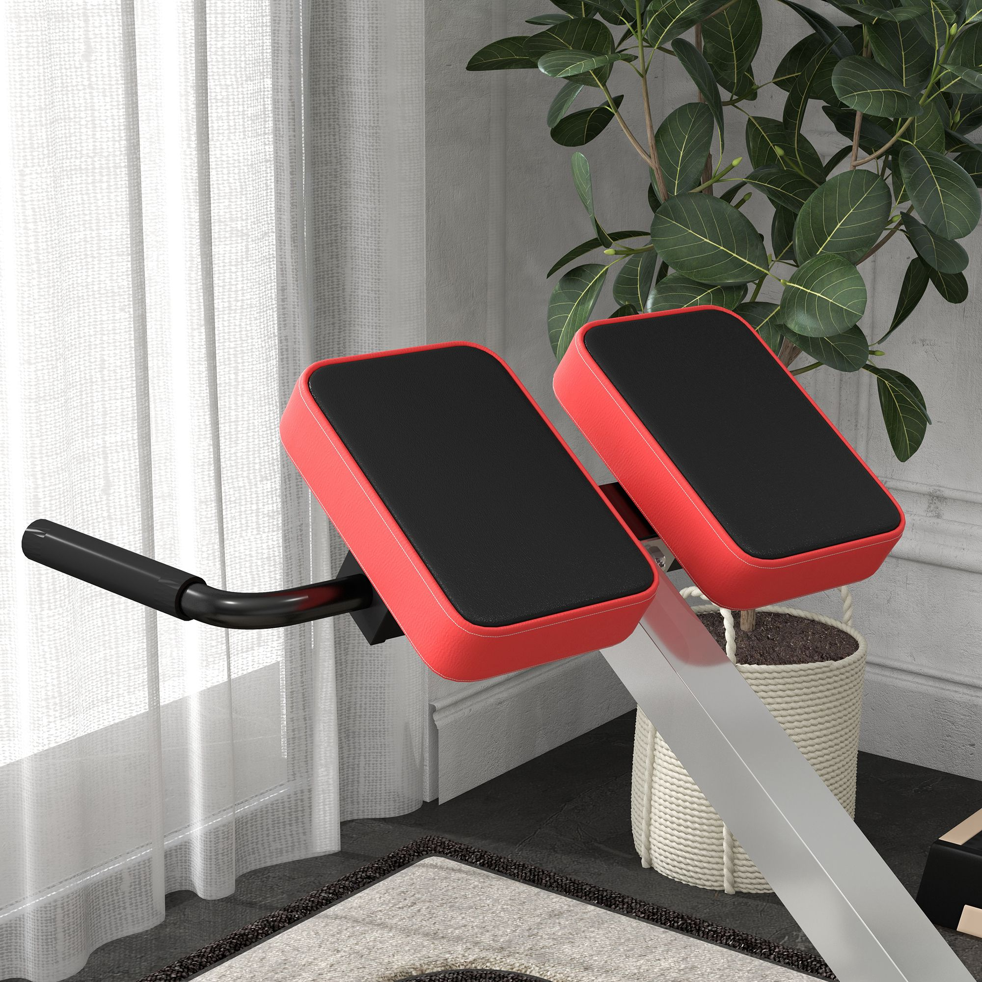 Un banco de extensión lumbar rojo y negro está en una habitación con planta y cortinas.