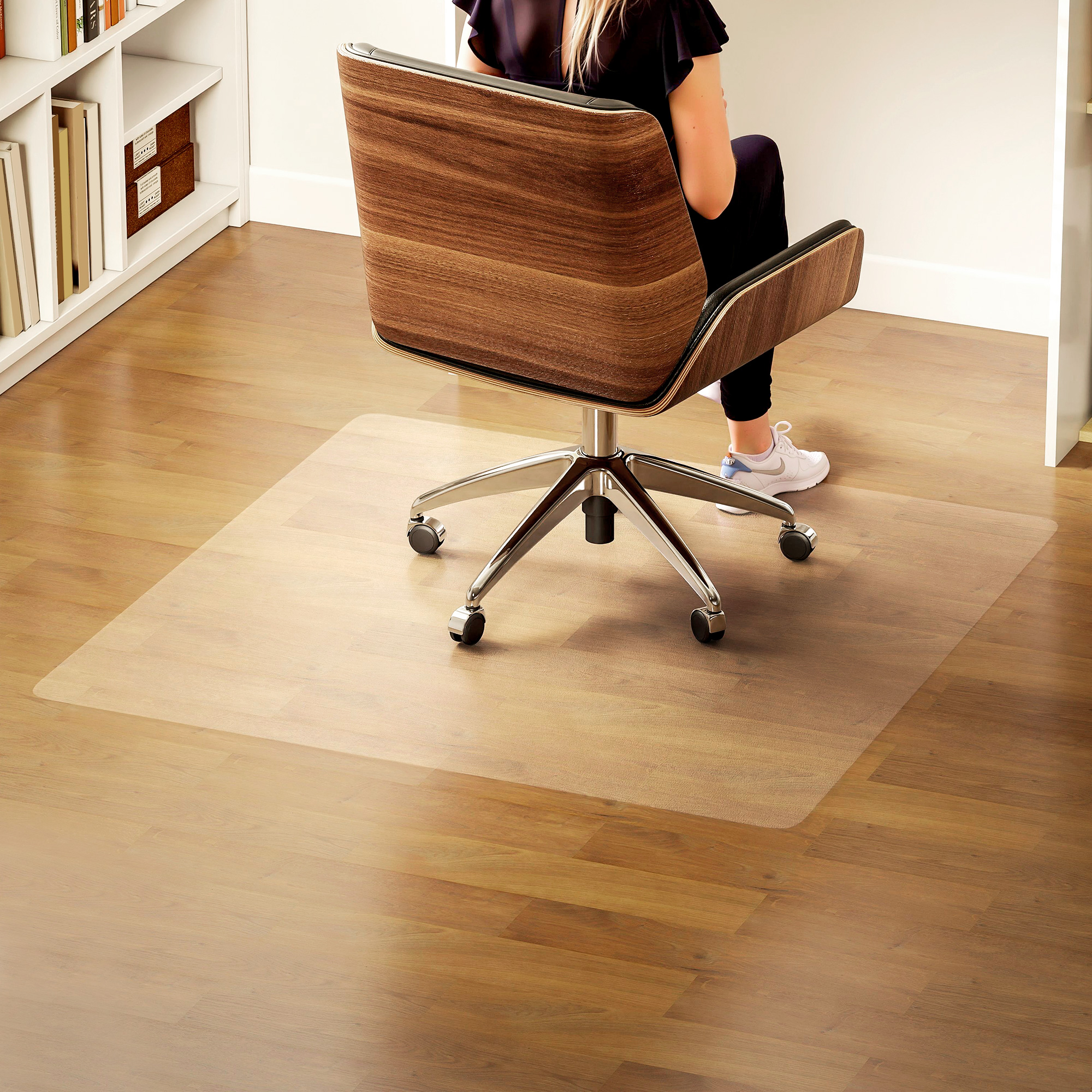 Persona se sienta en silla de madera sobre alfombra transparente protectora.