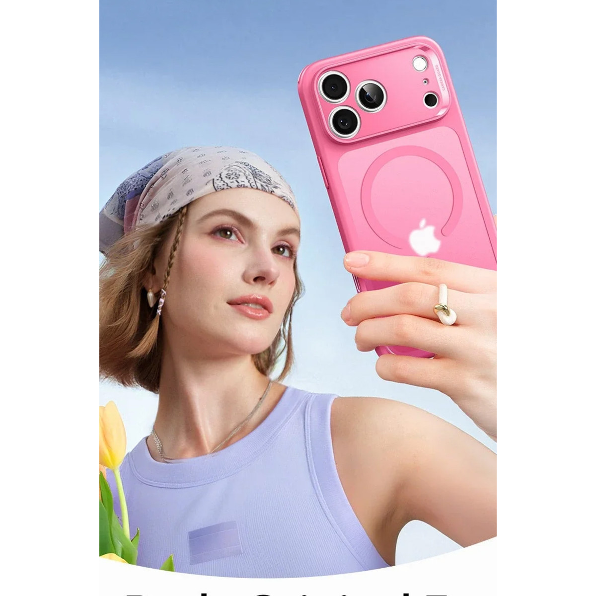 Mor üstlü ve başörtülü bir kadın, mavi gökyüzü fonunda pembe bir akıllı telefon tutuyor.