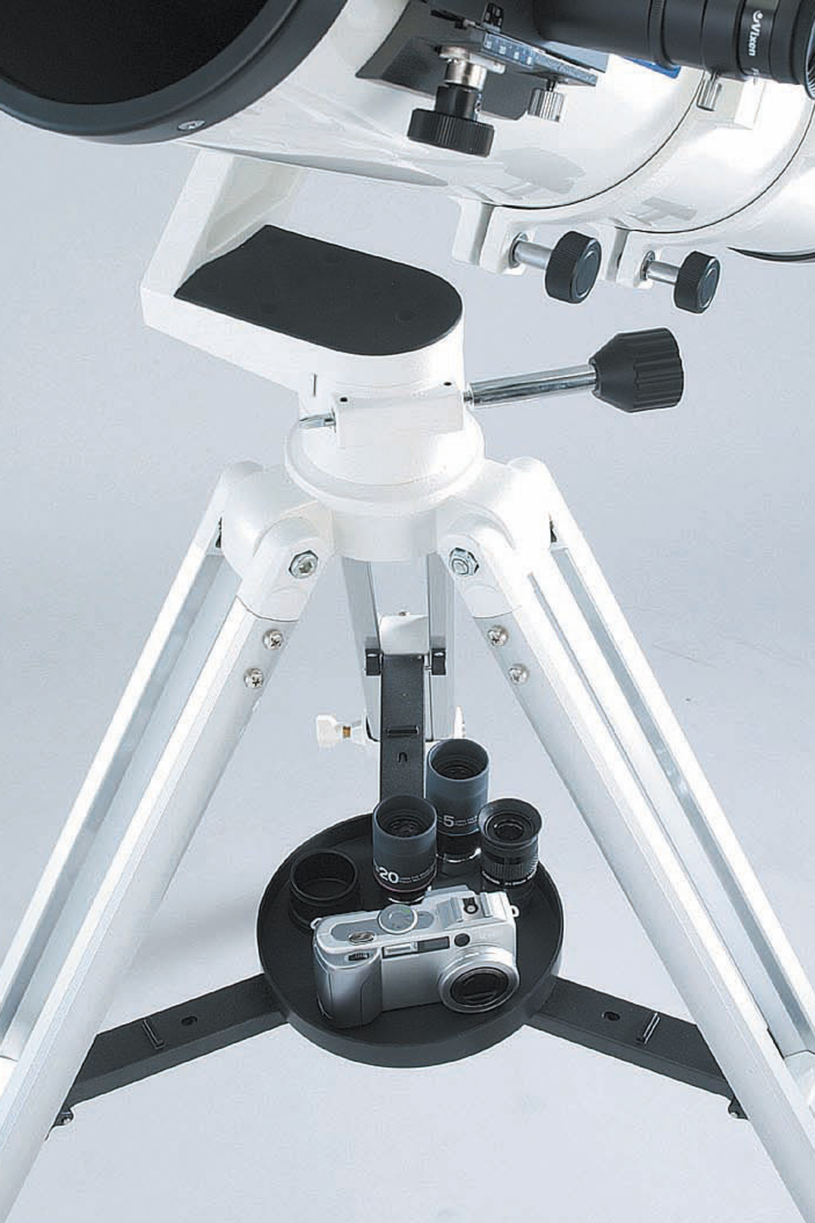 Un telescopio blanco en un tripode con una bandeja de accesorios con una camara y oculares.