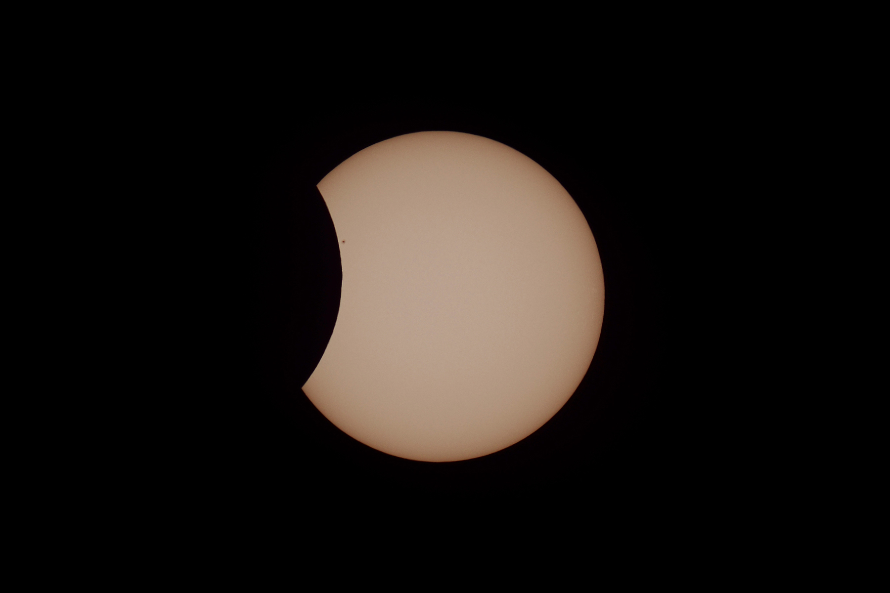 Un eclipse solar muestra el sol brillante parcialmente cubierto por una luna oscura sobre un fondo negro.