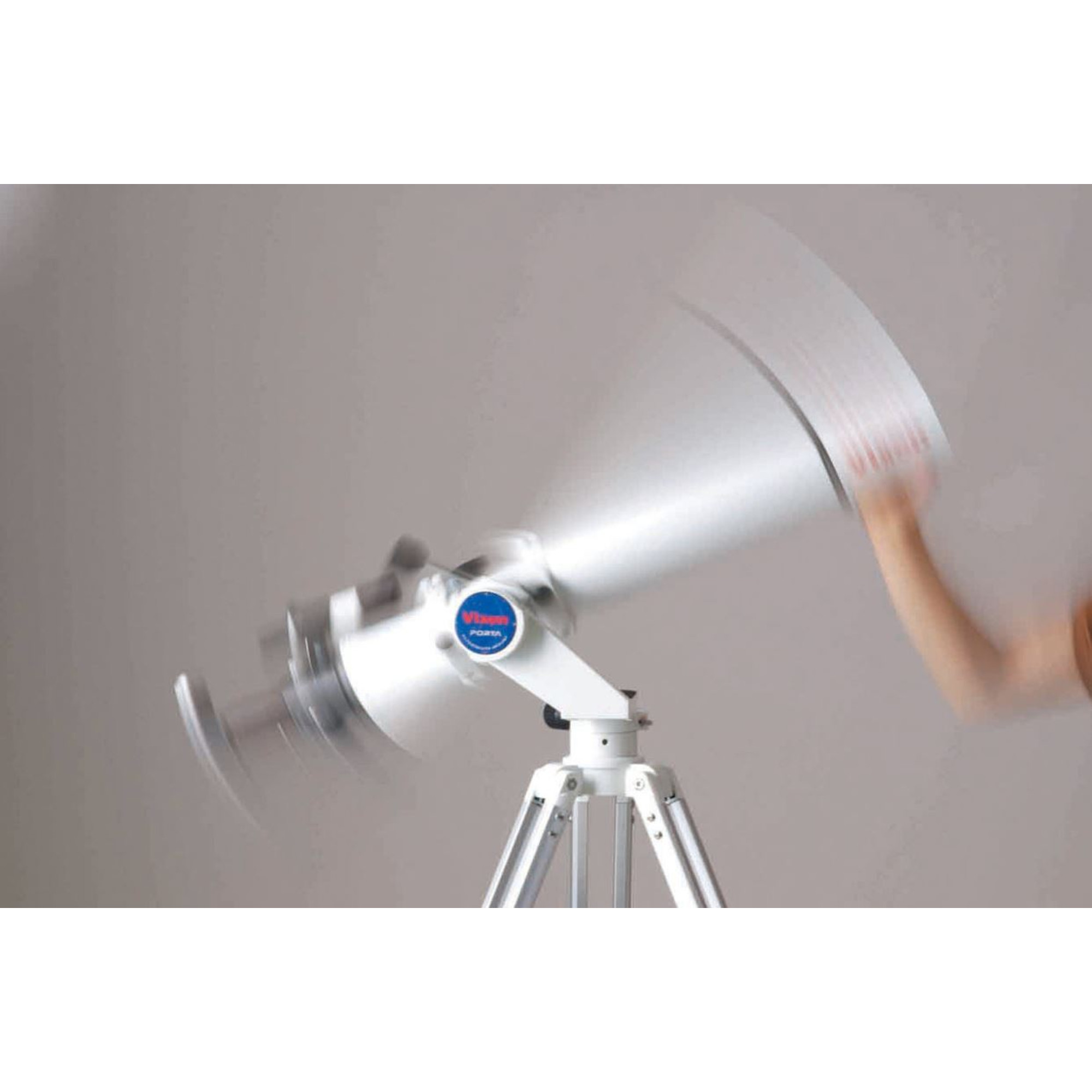 Una imagen borrosa de un telescopio en un trípode siendo movido por una mano.