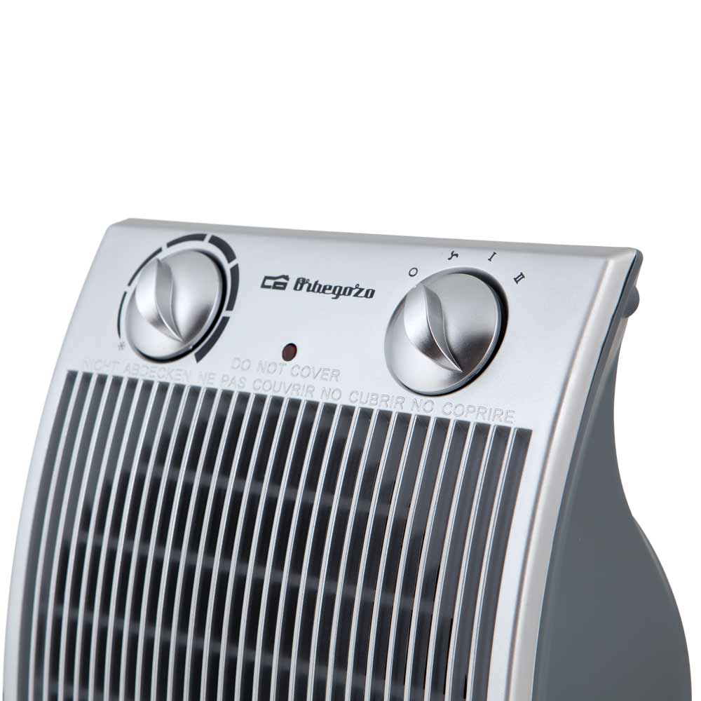 Primo piano dei controlli del termoventilatore grigio Orbegozo, con due manopole argento e griglia.