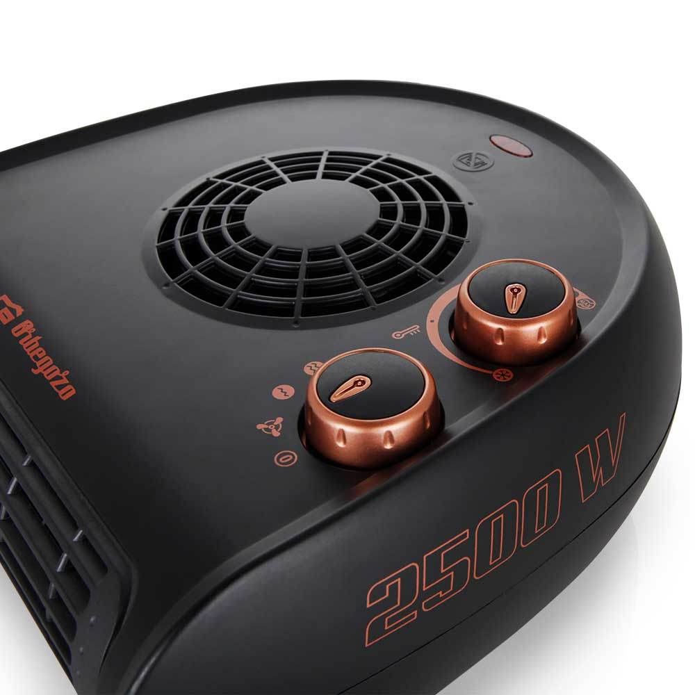 Un calefactor negro con perillas y rejilla de color cobre muestra el texto 2500 W.