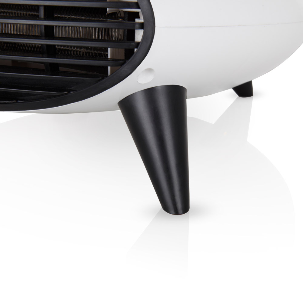Primer plano de las patas negras y la rejilla de un calefactor eléctrico blanco sobre fondo blanco.