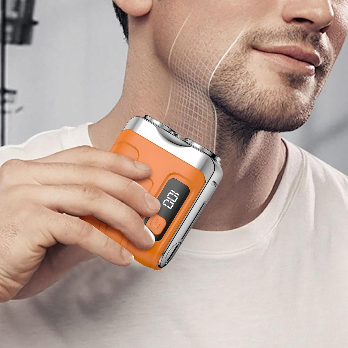 Ein Mann rasiert seinen Bart mit einem kleinen orangen Elektrorasierer.