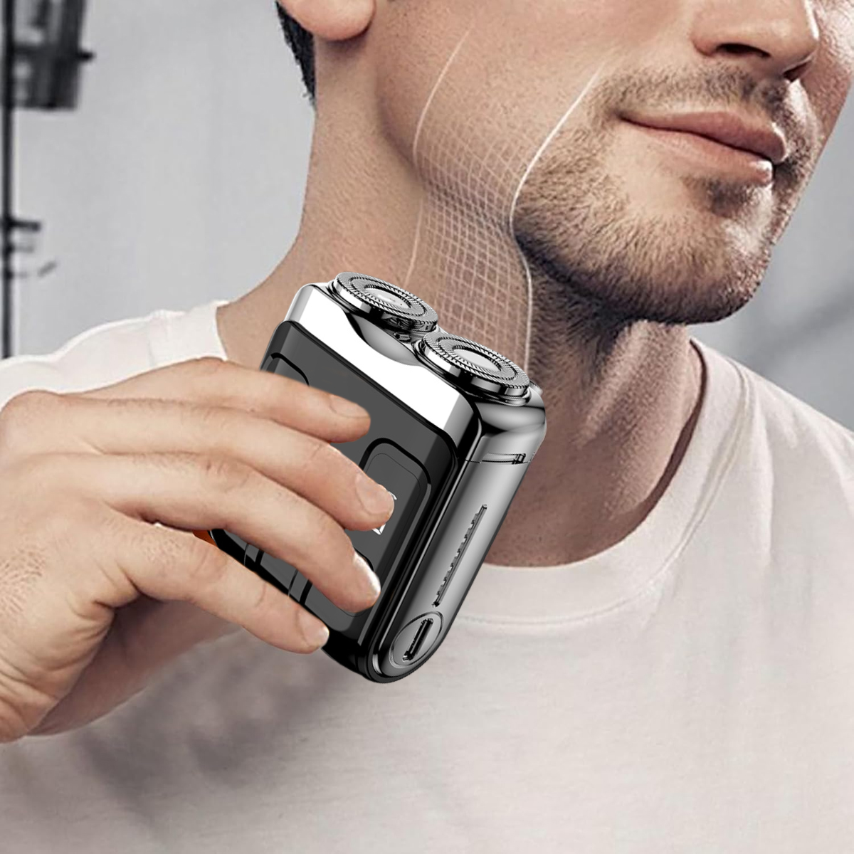 Ein Mann hält einen kleinen silber-schwarzen Elektrorasierer nah an sein Gesicht.