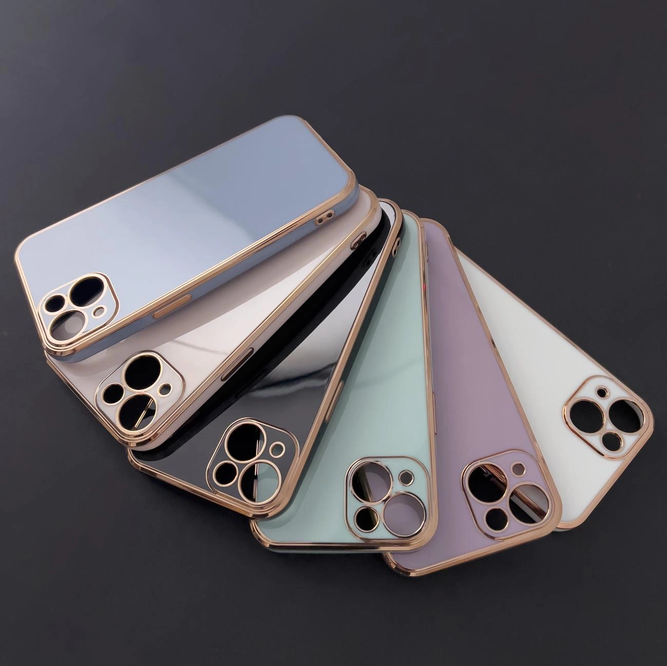 Sei custodie per cellulare colorate con bordi in oro rosa e ritagli per fotocamera su sfondo scuro.