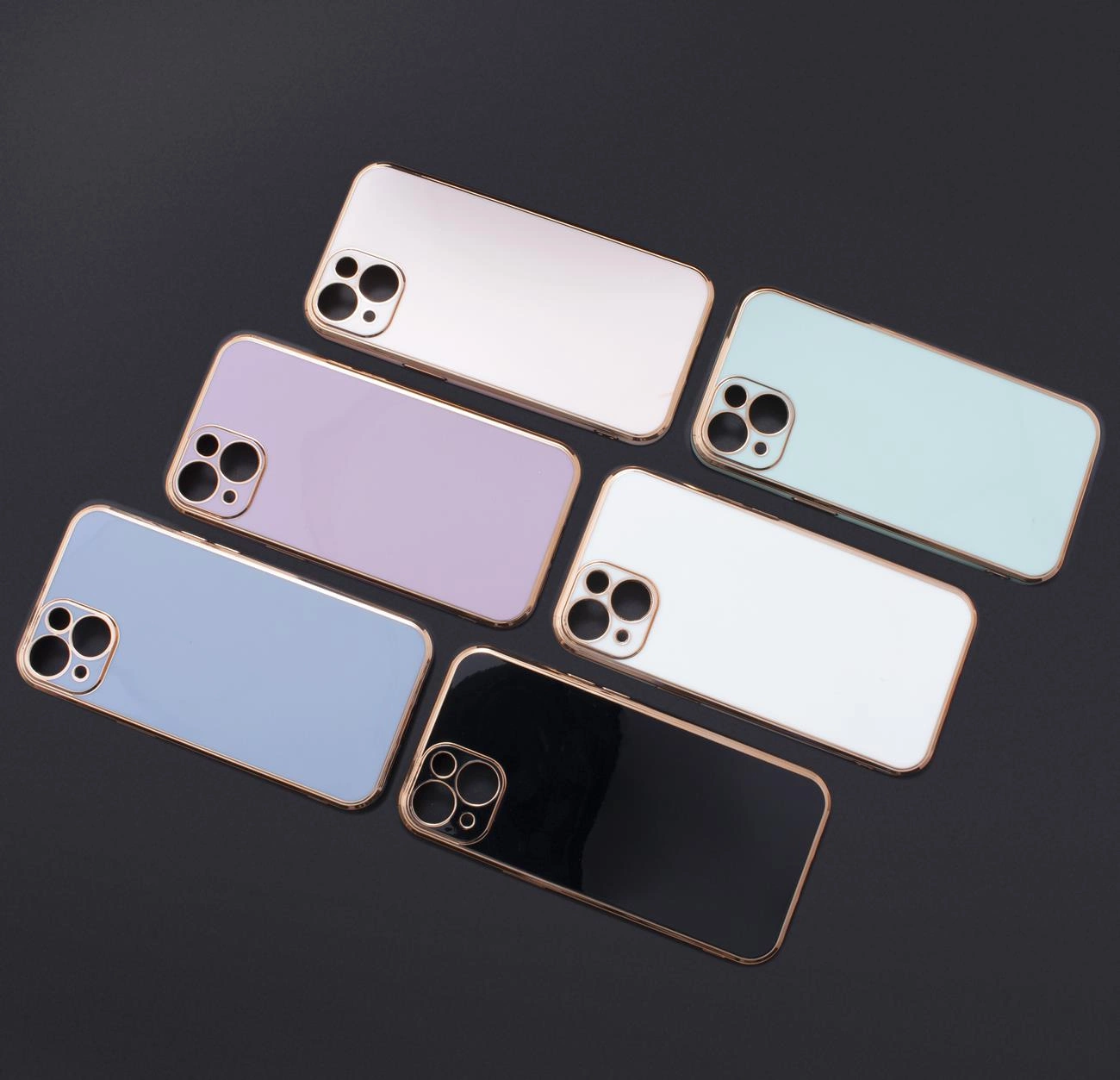 Sei cover per smartphone in colori pastello e nero, con bordi in oro rosa, disposte su sfondo scuro.