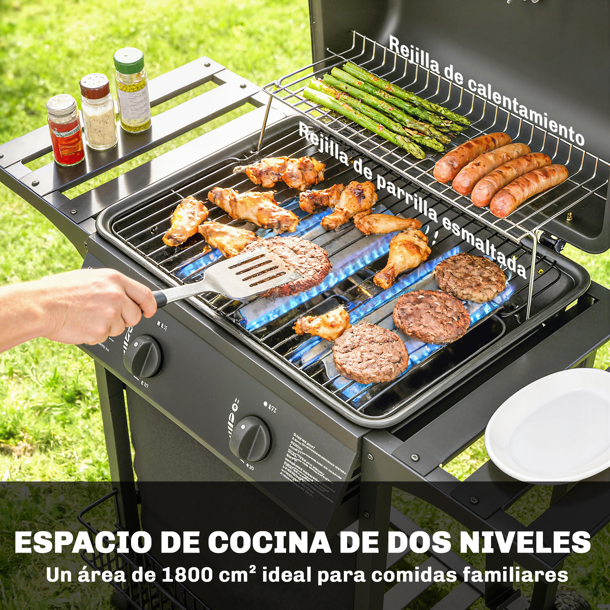 Parrilla de gas con espátula volteando una hamburguesa, pollo, salchichas y espárragos.