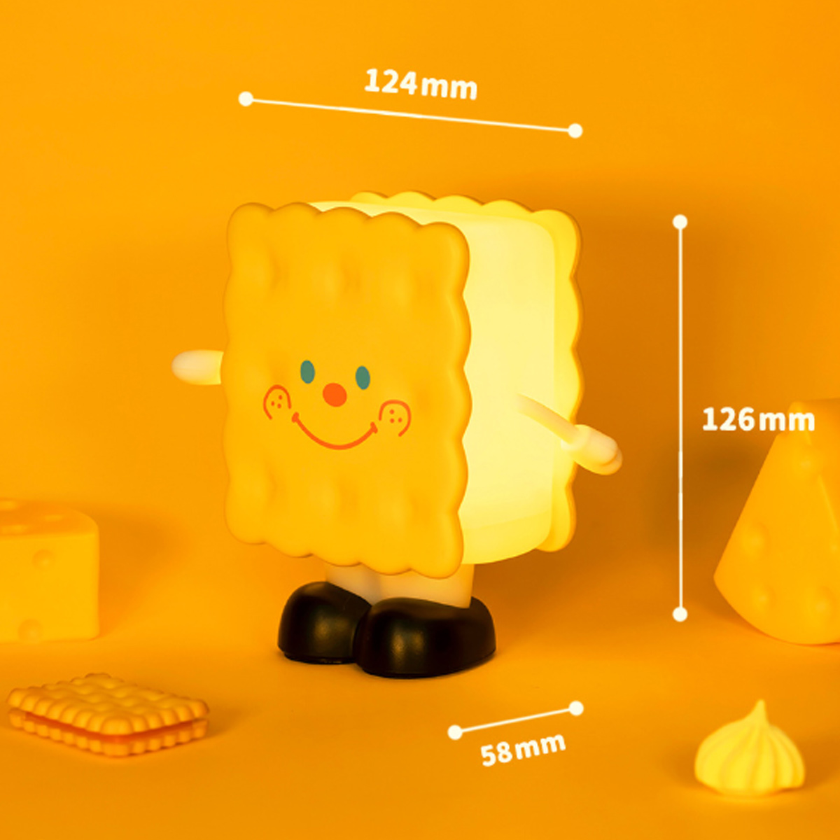 Niedliche keksförmige Lampe mit Beinen und Gesicht, umgeben von gelbem Hintergrund und Maßangaben.