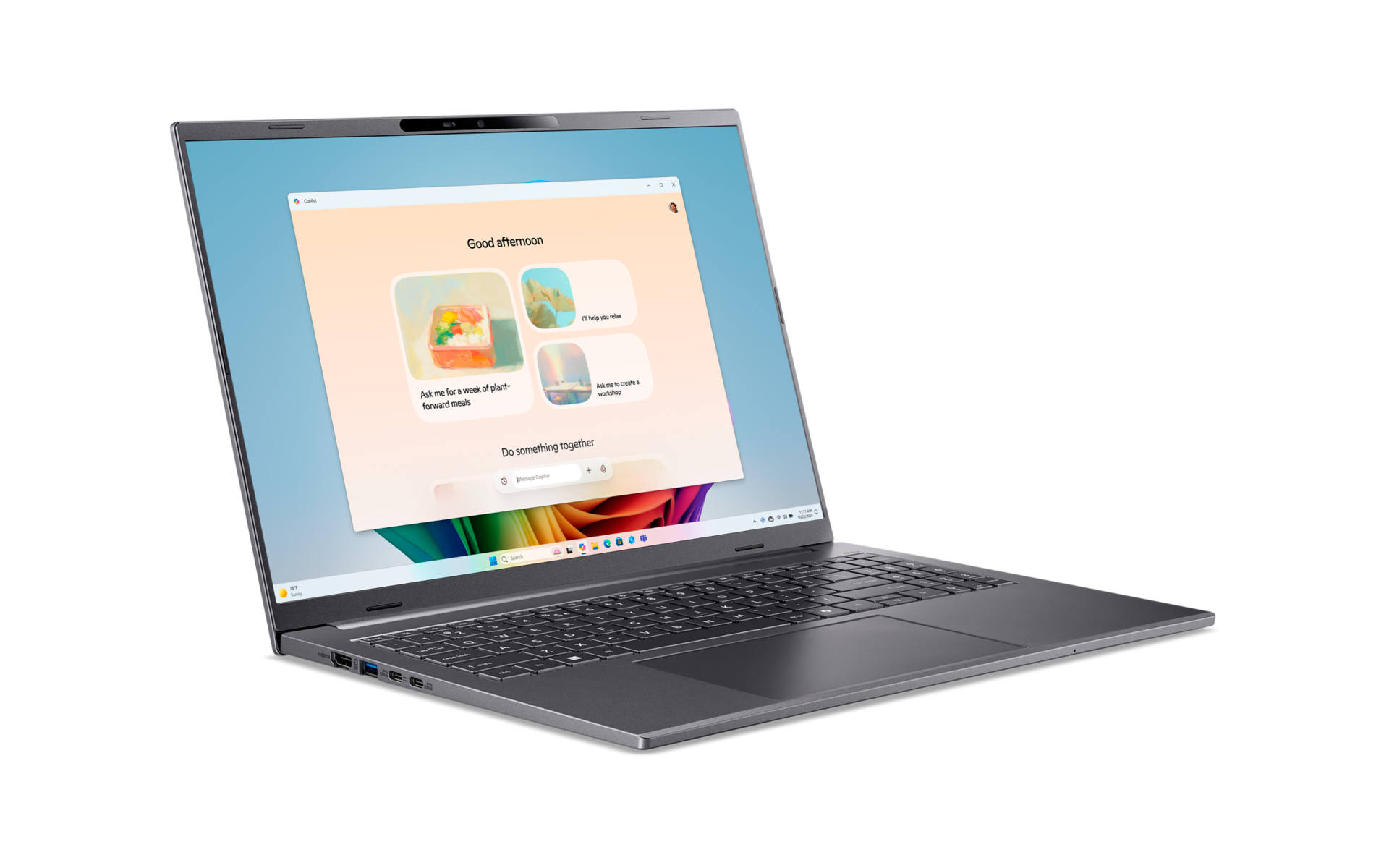 Ein grauer Laptop steht auf weißem Grund und zeigt das Copilot-Fenster auf dem Bildschirm.