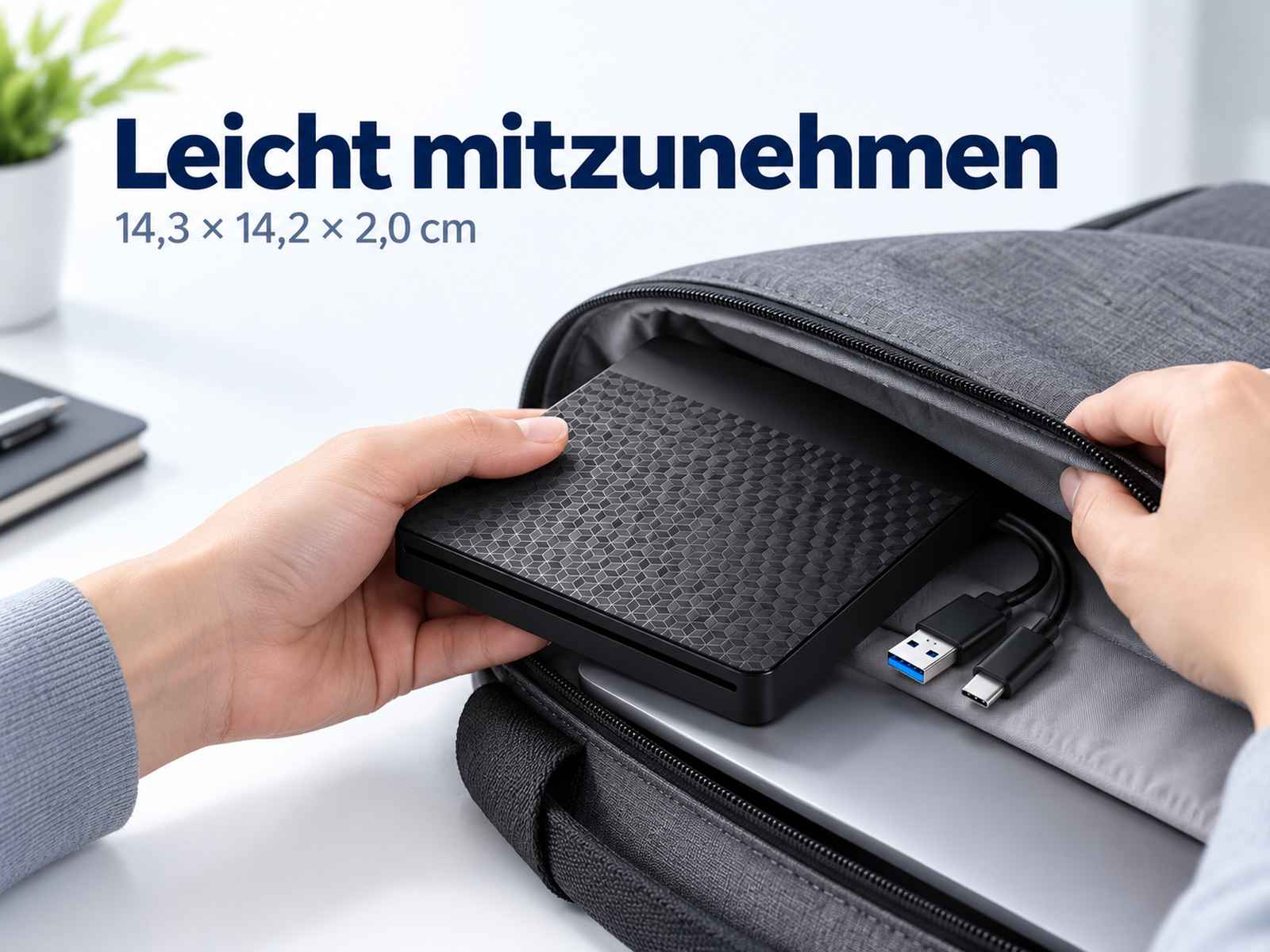 Eine Person packt ein schwarzes externes Laufwerk mit Wabenmuster in eine graue Tasche.