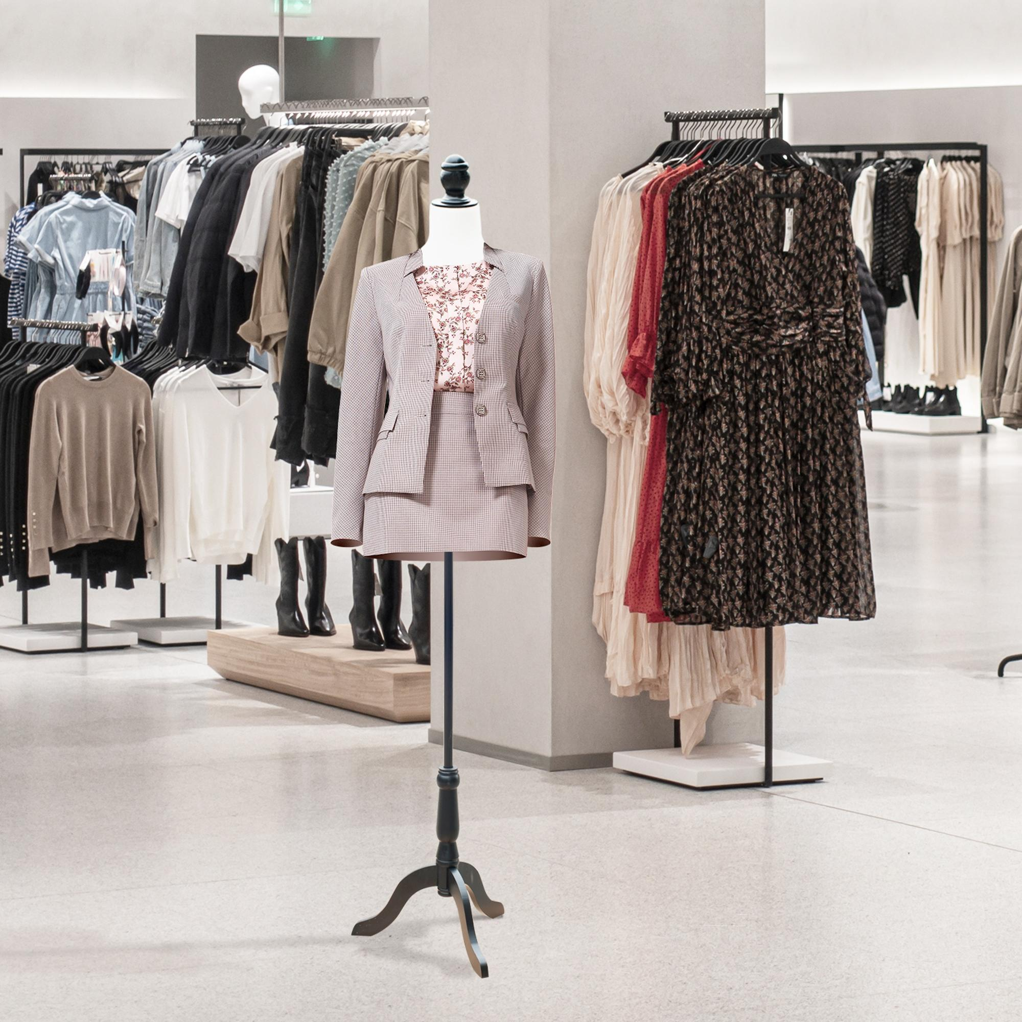 Un maniquí con traje de cuadros en una tienda de ropa luminosa con percheros al fondo.