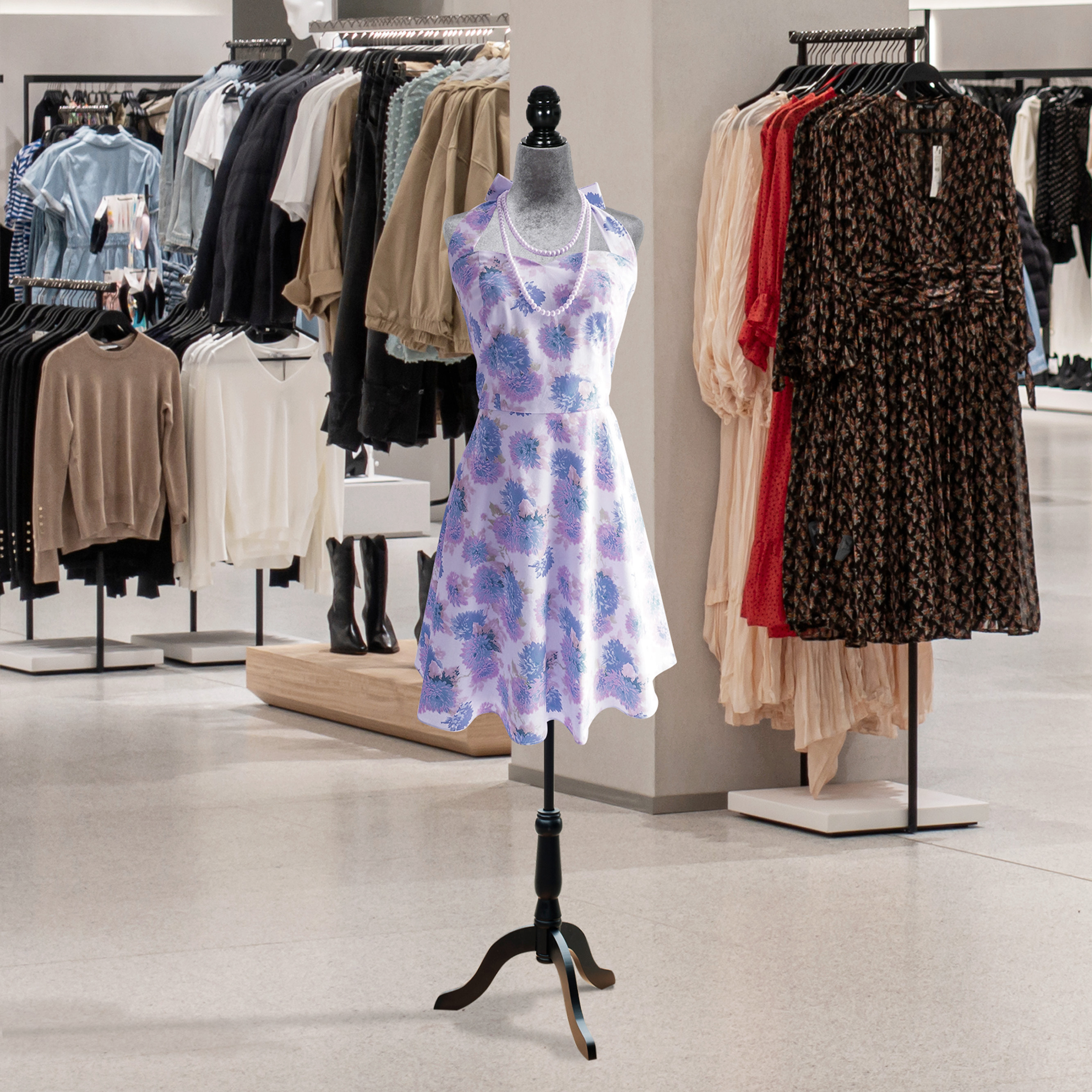 Un maniquí en una tienda de ropa viste un vestido sin mangas azul claro con estampado floral y collar de perlas.