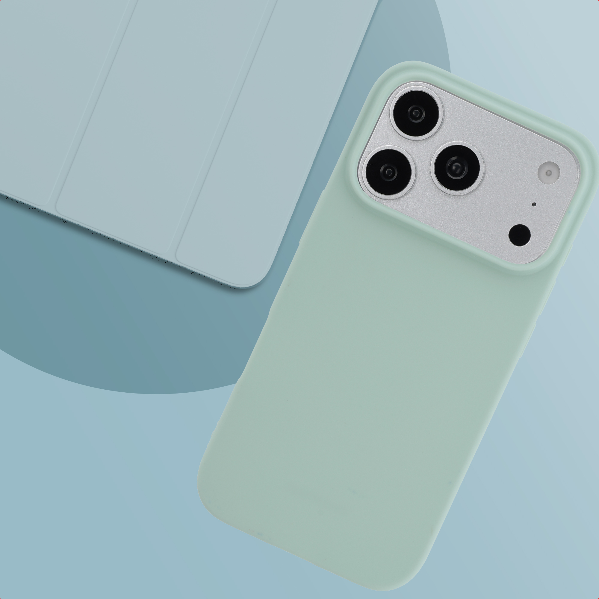 Lichtgroen telefoonhoesje met drie camera's en bijpassende lichtblauwe tablethoes op een blauwe achtergrond.