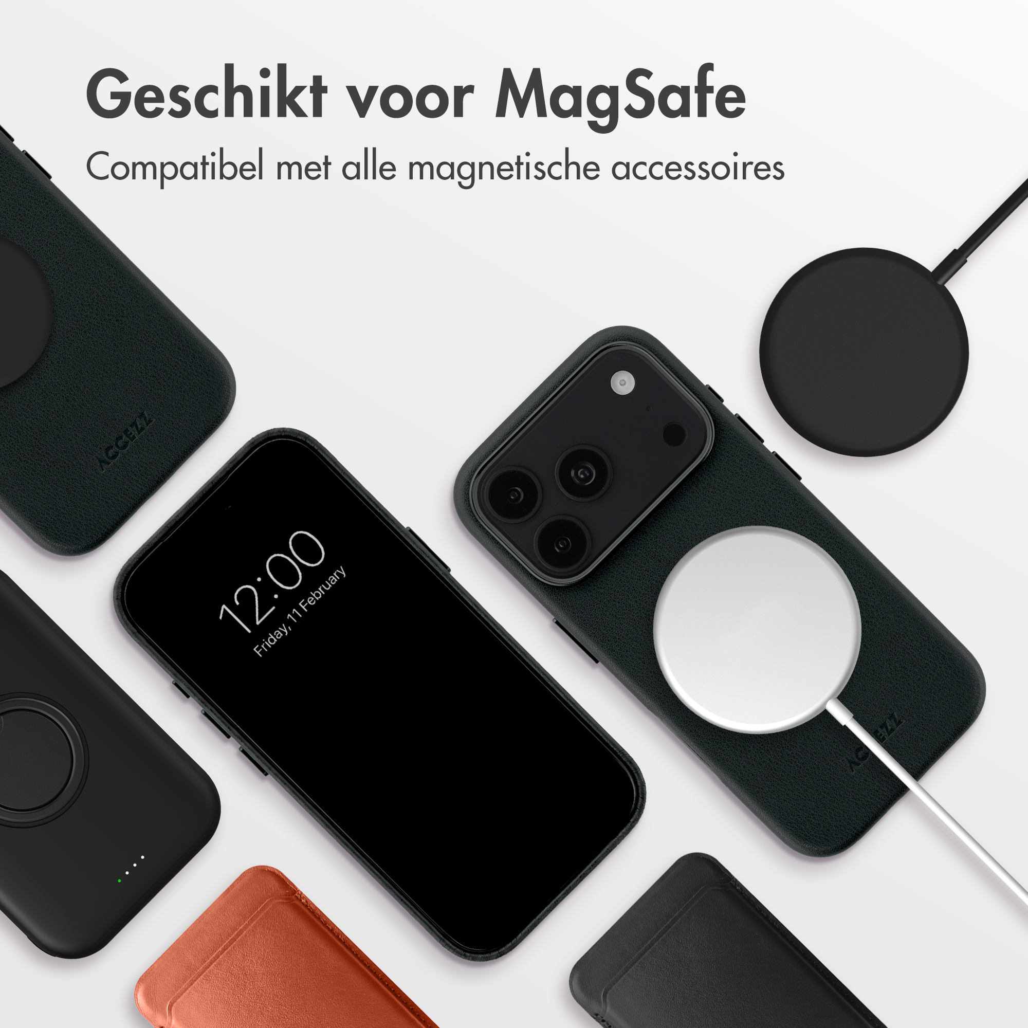 Schwarzes Smartphone in Hülle mit MagSafe-Ladegerät und Zubehör auf hellem Grund.